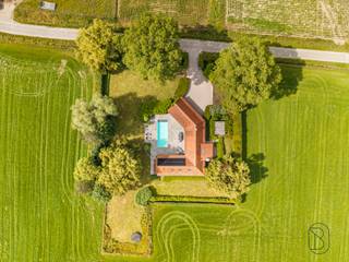 Te koop: charmante hoeve met zwembad op 3500m2 in Kruisem.
In het landelijke en gegeerde Kruisem bevindt zich deze prachtige hoeve op een uitzonderlijk perceel van maar liefst 3500 vierkante meter.
De eigendom, gebouwd in 1989, geniet van een volledig privatieve ligging en wordt omgeven door een mooie en ruime tuin, waardoor rust en privacy hier centraal staan.
Bij het betreden van de woning ervaar je meteen het aangename ruimtegevoel en de authentieke charme. De lichtrijke leefruimtes bieden een prachtig zicht op de tuin en het zwembad, dat zonder twijfel één van de absolute troeven van deze eigendom vormt. De woning beschikt bovendien over voldoende ruimte en mogelijkheden om een vrij beroep te combineren met wonen, wat dit pand extra interessant maakt voor zelfstandigen of thuiswerkers.
De uitgestrekte tuin en het ruime perceel bieden tal van mogelijkheden voor hobby’s, dierenliefhebbers of wie gewoon wil genieten van rust en natuur in alle privacy. Dankzij de gunstige ligging combineert deze hoeve landelijke rust met een vlotte bereikbaarheid.
Een unieke eigendom voor wie op zoek is naar ruimte, privacy en veelzijdigheid.
Interesse? Contacteer arne@immobeguin.be