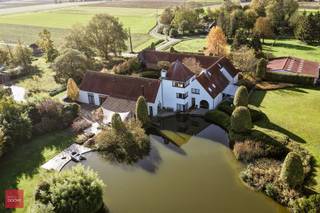 Gelegen op de grens met Wannegem-Lede, prachtig gerestaureerde vierkantshoeve op ca. 1,3ha bestaande uit inkomhal, living met open ingerichte...