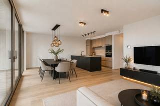 Op de 7de verdieping van residentie Pergola, in het hippe en bruisende De Nieuwe Dokken, bevindt zich dit uitzonderlijk luxueus afgewerkte appartement van maar liefst 121 m². Een stijlvolle woonbeleving waar ruimte, comfort en een fenomenaal uitzicht over het water en de stad Gent perfect samenkomen.<br />De ruime leefruimte baadt in het licht en sluit naadloos aan op het inpandige terras, vanwaar u elke dag geniet van een uniek zicht richting de Gentse binnenstad. De open keuken is volledig ingericht en afgewerkt met hoogwaardige materialen, perfect voor wie houdt van koken én gezellig tafelen.<br />Het appartement beschikt over twee ruime slaapkamers en een luxueuze badkamer met zowel een ligbad als een royale inloopdouche. In elke kamer, inclusief de badkamer, zijn stijlvolle ingemaakte kasten voorzien, waardoor comfort en opbergruimte hand in hand gaan.<br />De warme parketvloeren, gezellige inkomhal met zitbank en ingemaakte kasten en de ruime berging met extra maatkasten en wastafel onderstrepen de aandacht voor detail en wooncomfort.<br />Hier woont u in een rustige, moderne omgeving aan het water, maar tegelijk op wandelafstand van het historische centrum van Gent. Ook het station en de belangrijkste invalswegen zijn vlot bereikbaar.<br />Een bijzonder appartement voor wie verfijnd en comfortabel wil wonen op een toplocatie in Gent.<br /><br />Syndicuskosten: 150€/mnd<br />Bezoekdag: Woensdag 19 augustus