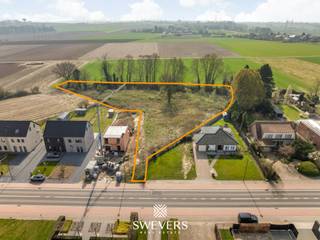 Voor meer info en foto’s, surf naar www.swevers.be – In de Maastrichterstraat in 3740 Bilzen-Hoeselt vindt u deze uitzonderlijk ruime bouwgrond van maar liefst 62a 98ca. Een zeldzame opportuniteit voor wie royaal wil wonen in het groen, zonder in te boeten op bereikbaarheid. Het perceel is 8 meter breed aan de straatzijde en verbreedt achteraan, wat interessante mogelijkheden biedt voor het ontwerpen van een halfopen bebouwing, onder voorbehoud van het bekomen van de nodige vergunningen. Met een indrukwekkende diepte van 108 meter geniet u hier van een open gevoel, veel privacy en een mooie natuurlijke aansluiting met het groen achteraan. De aangename oriëntatie zorgt bovendien voor een fijne lichtinval en een sterke connectie met de tuin en omgeving. Achteraan grenst het terrein aan een groene zone, wat rust en een mooi uitzicht garandeert. Dankzij de uitzonderlijke oppervlakte is dit perceel ook geschikt voor het houden van paarden of het aanleggen van een weide, ideaal voor wie landelijk wil wonen met extra buitenruimte. Toch liggen alle voorzieningen vlot binnen handbereik: scholen op 1,4 km, openbaar vervoer op 450 meter, het station op 3 km, ontspanning op 1 km, restaurants op 410 meter, winkels op 2 km en het centrum van Bilzen op 3 km. Ook de snelwegen bereikt u al op 5 km. Een perceel dat ruimte, rust en potentieel op een unieke manier samenbrengt. Voor meer informatie, bel 012 699 900.