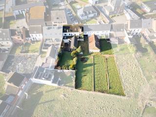 Dit onroerend goed (mogelijkheid tot project met appartementen - woningen) bestaat uit een ruime handelswoning met praktijkruimte (vroeger advocatenkantoor) en bijhorende bouwgrond(en) gelegen op wandelafstand van het centrum van Denderhoutem. De woning kan opgesplitst worden in verschillende appartementen en de gronden verkavelbaar. In de woning hebben we een leefruimte en een praktijkruimte die gescheiden zijn waardoor dit pand ideaal is voor zelfstandigen die woon-werk willen combineren of er één grote handelsruimte te creëren .De praktijkruimte werd 8 jaar geleden verbouwd en omvat een kantoorruimte, vergaderzaal, bergruimte, bureau, extra berging met goederenlift, een overloop en toilet. Verder bestaat het gelijkvloers over een aparte inkomhal, een garage, ruime living (50 m²) met veel lichtinval, een keuken met eetplaats met daarboven een mezzanine. Het verdiep dient gerenoveerd te worden en bestaat uit een nachthal, vijf ruime slaapkamers, een badkamer, een extra badkamer die nog ingericht moet worden en een toilet. Via een vaste trap bereikt men het zolderverdiep waarop nog de creatie van meerdere slaapkamers mogelijk is. Tevens beschikt men over een ruime kelder, terras en tuin met veel mogelijkheden. +/- 40 zonnepanelen aanwezig met certificaten. CV op stookolie. Buitenschrijnwerk in hout met dubbele beglazing - Dak in asbest met isolatie - Alarm aanwezig. Winkels, scholen en openbaar vervoer bevinden zich in de nabijheid. De oprit E-40 bereikt men op enkele minuten rijden. Voor meer info hyboma.be. Wenst u graag een bezoek ter plaatse contacteer dan Guy 0479/88 88 06.