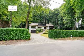 Ontdek deze unieke eigendom in Maarkedal, waar elegantie en natuurlijke schoonheid naadloos samenkomen. Met een indrukwekkende bewoonbare oppervlakte van 453 m², midden in een bosrijk landschap en omringd door weelderig groen, biedt deze woning een oase van rust en verfijning.Bij binnenkomst verwelkomt een ruime inkomhal u en leidt u naar een lichtrijke woonkamer, ideaal voor gezellige avonden met familie en vrienden. De stijlvolle eetkamer sluit aan op een te moderniseren keuken die direct toegang geeft tot een zonneterras. Hier beleeft u ontspannen diners in openlucht, omgeven door stilte en groen.De woning beschikt over vijf slaapkamers en twee badkamers, waardoor er voldoende ruimte is voor een groot gezin of logees. Het interieur ademt nostalgie en warmte, verrijkt met vintage accenten die zorgen voor een tijdloze uitstraling.Verder ontdekt u een royale kelderverdieping met wijnkelder. De dubbele garage biedt niet alleen plaats voor meerdere voertuigen, maar is ook dienstig voor praktische bergruimte.Ook buiten is dit eigendom een parel: de tuin garandeert privacy en vormt een waar paradijs voor natuurliefhebbers. Deze woning combineert rust, ruimte en authenticiteit met talloze mogelijkheden voor persoonlijke invulling. Een zeldzame kans om een stukje paradijs in het hart van de natuur uw thuis te noemen.