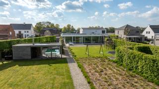 Schitterende moderne villa (bouwjaar 2001) met kantoren/praktijk of extra leefruimte op prachtige kavel van 3.140 m² is gelegen nabij het centrum van Dessel. Deze villa is afgewerkt met hoogwaardige materialen, geniet van enorm veel lichtinval en heeft bovendien een prima EPC-score van 137 kWh/m²/jaar (B-label). Het eigendom omvat zeer mooie open leefruimtes met exclusieve keuken, een complete wellness, wijnkelder, 3 slaapkamers, 2 badkamers, een grote garage, een aparte vleugel die momenteel dienst doet als praktijk, maar perfect kan omgevormd worden tot bv gastenverblijf, kantoren of extra leefruimte,... zeer mooie tuin met buitenzwembad en poolhouse. <br /><br />Gelijkvloers: <br />Via een stijlvolle inkomhal met vestiaire en gastentoilet bereikt u de villa. De grote pivot deuren brengen u naar de imposante woonkamer met hoge plafonds (3m) en een gezellige doorkijkhaard tussen de eetkamer en de zithoek. De moderne leefkeuken met minimalistisch design en natuurstenen werkblad is voorzien van alle comfort met oa een AGA kookfornuis voorzien van 4 ovens. De keuken staat in rechtstreeks contact met de overige leefruimte. Zo treft u hier nog een sfeervolle zithoek met aanpalend kantoor op parket, dewelke volledig kan worden afgesloten van de woonkamer. De grote raampartijen aan de volledige achterzijde van deze villa zorgen voor enorm veel daglicht. U geniet van een rechtstreekse toegang van de leefruimtes naar het overdekte terras aan de achterzijde. Van hieruit kunt u heerlijk genieten met zicht op uw schitterend aangelegde tuin. <br />De zij-inkom biedt toegang tot het praktisch gedeelte van de villa. Hier treft u een volledig ingebouwde kastenwand, een badkamer met ruime inloopdouche en toilet. Via de hal bereikt u de dubbele garage met elektrische poort.<br />Het praktijkgedeelte beschikt over een separate inkomhal met een wachtkamer en onthaalruimte. Hier bevinden zich 3 volledig uitgeruste behandelkamers/kantoren en een royale fitnessruimte/polyvalente ruimte. <br /><br />Eerste verdieping:<br />Via de trappenhal bereikt u de eerste verdieping met 3 slaapkamers, waaronder 2 kinderkamers en een ruime masterbedroom met aangrenzende dressing. De verdieping is volledig voorzien van massieve parketvloeren. De badkamer is uitgerust met Travertin en Carrara<br />marmer, een Philippe Starck-ligbad en Vola-kranen. De inloopdouche werd recent nog gerenoveerd.<br /><br />Kelderverdieping/Wellness:<br />De volledig onderkelderde verdieping is ingericht als een exclusieve privé-wellness. U vindt hier oa een jacuzzi, een hammam, een luxe sauna met dompelbad, een keienbad, wisselbaden en verwarmde ligbanken met kleurentherapie. Loungeruimte met houthaard aanwezig om gezellig te ontspannen. Er zijn ook 2 buitendouches aanwezig. De gehele<br />kelderverdieping, inclusief de wasplaats, is afgewerkt met een granieten natuurstenen vloer. Er werd geopteerd voor kraanwerk van het exclusieve merk Dornbracht. Naast de wellness bevinden zicht 3 extra kamers die multifunctioneel gebruikt kunnen worden, alsook een aparteruimte met infraroodcabine en douche. De wellness kreeg een nominatie voor de “Mooiste Privésauna van Vlaanderen” door Knack-Wellness.<br /><br />Tuin:<br />Het perceel is volledig omheind en aangelegd met een royaal terras en een verwarmd zwembad met poolhouse, dat is uitgerust met toilet en douche. De gevelbekleding van Massangis kalkzandsteen. De zuidoostelijke oriëntatie zorgt voor optimaal zonlicht, en de voortuin biedt parkeerruimte voor 7 - 10 auto’s, exclusief de garage. <br /><br />Bijzonderheden:<br />- Ideale woning voor de thuiswerker, een gezin of koppel dat wil genieten van alle luxe comfort.<br />- Strakke afwerking/interieur: weggewerkte plinten, ingebouwde verlichting, maatwerk kasten... <br />- Conforme elektriciteitskeuring<br />- Zwembad wordt dmv warmtepomp<br />- Zonnepanelen - ca. 11.000 kwh/m²<br />- Asbestveilig<br />- EPC label B<br />- Grondwaterput van 203m diepte