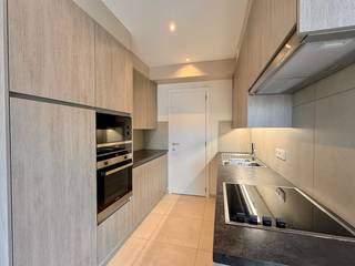 Appartement met twee slaapkamers en garage in het centrum van De Panne.Inkomhal, lichtrijke woonkamer, open en ingerichte keuken met berging en...