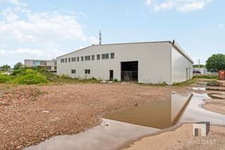 <p><span>Unieke nieuwbouwloods op strategische KMO-locatie in Diest </span></p><p><span>Verkoop onder BTW-stelsel van 21%, volledig te verrekenen via de BTW-aangifte voor BTW-plichtige kopers. </span></p><p><span> </span></p><p><span>Op de KMO-zone aan de Nijverheidslaan in Diest bevindt zich deze uitzonderlijke nieuwbouwloods op een royaal perceel van 37,85 are. </span></p><p><span>Dankzij haar ligging in een bedrijvige en goed bereikbare zone vormt dit pand een bijzonder interessante opportuniteit voor ondernemers, zelfstandigen en investeerders die op zoek zijn naar ruimte, flexibiliteit en toekomstgerichte doorgroeimogelijkheden.</span></p><p><span> </span></p><p><span>De loods heeft een indrukwekkende oppervlakte van circa 1.020 m², met afmetingen van ongeveer 30 meter breed op 34 meter diep. </span></p><p><span>De vrije hoogte van meer dan 6 meter zorgt voor een bijzonder ruimtelijk gevoel en biedt tal van praktische mogelijkheden op vlak van stockage, werkruimte, circulatie en eventuele verdere inrichting.</span></p><p><span>Ruimte voor uitbreiding met mezzanine of extra functies </span></p><p><span>Dankzij de grote vrije hoogte kan er op niveau 1 via een metaalconstructie een bijkomend platform of mezzanine worden gerealiseerd van ongeveer 300 m². Deze extra oppervlakte kan perfect worden ingericht als:</span></p><p><span>bureelruimte; <br />extra stockage; <br />personeelsruimte; <br />showroom; <br />vergaderruimte; <br />klantenontvangst; <br />of eventueel als conciërgewoning/bedrijfswoning, steeds onder voorbehoud van de geldende voorschriften, vergunningen en stedenbouwkundige mogelijkheden.</span></p><p><span> </span></p><p><span>Deze flexibiliteit maakt het gebouw bijzonder interessant voor bedrijven die vandaag al ruimte nodig hebben, maar tegelijk willen anticiperen op toekomstige groei.</span></p><p><span> </span></p><p><span>Een bijkomende troef is dat de structuur reeds voorzien is om achteraan de loods een aparte hal van circa 225 m² te creëren. </span></p><p><span>Deze ruimte kan beschikken over een aparte toegang en een afzonderlijk bureel. Bovendien zijn de nodige materialen hiervoor reeds aanwezig.</span></p><p><span> </span></p><p><span>Dit biedt interessante mogelijkheden voor: </span></p><p><span>gescheiden bedrijfsactiviteiten; <br />interne compartimentering; <br />verhuur van een gedeelte van het gebouw; <br />combinatie van eigen gebruik en opbrengst; <br />opslag of atelier met afzonderlijke toegang. </span></p><p><span> </span></p><p><span>Voor ondernemers of investeerders kan dit dus een waardevolle extra troef zijn, zeker gezien de grote vraag naar dergelijke bedrijfsruimtes in de regio.</span></p><p><span> </span></p><p><span>Er is momenteel een duidelijk tekort aan moderne, ruime en functionele loodsen in deze categorie. Dit pand speelt perfect in op die vraag en is uitermate geschikt voor ondernemers die nood hebben aan een praktische, veilige en goed bereikbare uitvalsbasis.</span></p><p><span>Onder meer volgende activiteiten kunnen hier uitstekend worden ondergebracht: </span></p><p><span>transporten logistieke ondernemingen; <br />bouwgerelateerde bedrijven zoals dakwerkers, schrijnwerkers, installateurs en aannemers; <br />grondwerkers en tuin-/omgevingsbedrijven; <br />verhuur- en servicebedrijven actief in machines, voertuigen, tenten of materialen; <br />bedrijven met nood aan grote opslagcapaciteit; <br />ondernemingen die voertuigen, voorraad of materieel veilig willen stallen; <br />handelszaken met combinatie van stockage, burelen en klantenontvangst; <br />autogerelateerde activiteiten zoals verkoop, voorbereiding, opslag of lichte serviceactiviteiten. </span></p><p><span> </span></p><p><span>Door de combinatie van oppervlakte, hoogte, bereikbaarheid en uitbreidingsmogelijkheden is dit gebouw ideaal voor bedrijven die structuur, efficiëntie en groeipotentieel belangrijk vinden.</span></p><p><span>Kwalitatieve constructie en casco winddichte oplevering </span></p><p><span>De loods wordt opgetrokken in een stevige staalstructuur met hoogwaardige sandwichpanelen van 15 cm als buitenschil. Deze opbouw zorgt voor een duurzame, onderhoudsvriendelijke en energie-efficiënte basisconstructie.</span></p><p><span>Het gebouw wordt opgeleverd casco winddicht, inclusief: </span></p><p><span>dakconstructie; <br />ramen en deuren; <br />poorten; <br />solarinstallatie van circa 16.000 Wp; <br />nutsleidingen voor water en elektriciteit tot aan de meters. </span></p><p><span>De verdere afwerking kan gebeuren in overleg met de verkoper, zodat de koper het gebouw nog optimaal kan aanpassen aan de eigen bedrijfsnoden en activiteiten.</span></p><p><span>Omgevingswerken inbegrepen </span></p><p><span>Ook de buitenaanleg maakt deel uit van het project. De omgevingswerken omvatten onder meer: </span></p><p><span>verharding van de wegenis met steenslag</span></p><p><span>aanleg van parking; <br />voorziening van een wadi voor infiltratie en buffering van hemelwater; <br />duurzame waterhuishouding op het perceel. </span></p><p><span> </span></p><p><span>Daarnaast worden er parkeerplaatsen voorzien op het terrein. Dit is een belangrijke meerwaarde voor bedrijven met personeel, klantenbezoek of leveringen.</span></p><p><span>Sterke investering op een schaarse markt </span></p><p><span>Loodsen met deze oppervlakte, hoogte en uitbreidingsmogelijkheden zijn schaars in de regio. De ligging op een KMO-zone in Diest, gecombineerd met de ruime perceeloppervlakte, de casco oplevering en de mogelijkheid tot verdere inrichting op maat, maakt dit pand bijzonder aantrekkelijk voor zowel eindgebruikers als investeerders.</span></p><p><span> </span></p><p><span>Wie vandaag op zoek is naar een moderne bedrijfsruimte met toekomstpotentieel, vindt hier een bijzonder compleet en veelzijdig aanbod.</span></p><p><span>Troeven in één oogopslag </span></p><p><span>Nieuwbouwloods op KMO-zone Nijverheidslaan te Diest <br />Perceel van 37,85 are <br />Loods van circa 1.020 m² <br />Afmetingen: ongeveer 30 m x 34 m <br />Vrije hoogte van meer dan 6 meter <br />Mogelijkheid tot mezzanine/platform van circa 300 m² <br />Mogelijkheid tot aparte hal achteraan van circa 225 m² <br />Aparte toegang en bureel mogelijk voor achterste gedeelte <br />Interessant voor gedeeltelijke verhuur <br />Staalstructuur met sandwichpanelen van 15 cm <br />Casco winddichte oplevering <br />Inclusief poorten, ramen, deuren en dak <br />Solarinstallatie van circa 16.000 Wp voorzien <br />Nutsvoorzieningen water en elektriciteit tot aan de meters <br />Parking, tuinaanleg en wadi inbegrepen <br />Verdere afwerking bespreekbaar met de verkoper <br />Verkoop onder BTW-stelsel van 21% </span></p><p><span>Interesse? </span></p><p><span>Bent u op zoek naar een ruime, moderne en toekomstgerichte bedrijfsloods in Diest? Dan is dit pand absoluut het ontdekken waard.</span></p><p><span>Neem vandaag nog contact op met Immo Diest voor meer informatie of een bezoek ter plaatse. </span></p><p><span>Immo Diest <br /></span><span>📞</span><span> 013 31 25 22 <br /></span><span>✉️</span><span> <span>info@immodiest.be</span></span><span> </span></p><p><span>Of rechtstreeks via: <br />Jan Vanonckelen <br /></span><span>📞</span><span> 0498 52 64 52 <br /></span><span>✉️</span><span> <span>jan.vanonckelen@immodiest.be</span></span><span> </span></p><p><span> </span></p><p><span> </span></p><p><span> </span></p>