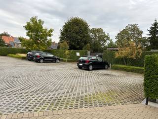 Deze privé parkeerplaats bevindt zich achter een appartementsgebouw en is vrij toegankelijk,.