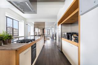 <span>Disposition</span>:<br /><br />Découvrez ce loft exclusif avec caractère, situé au cœur du centre animé d’Anvers. Ce logement luxueux et spacieux d’environ 325 m² se trouve dans un magnifique bâtiment art déco bien entretenu datant de 1937, conçu par l’architecte Apollon Lagache. Le loft allie un cadre historique à une finition contemporaine, où chaque détail témoigne du confort et de l’élégance. Le mélange stylé de matériaux chaleureux, comme le parquet massif foncé, et d’éléments modernes et frais tels que la cuisine en inox et les cloisons en verre, crée une atmosphère unique et raffinée.<br /><br />Au cinquième étage, vous pénétrez dans le loft par un hall d’entrée élégant avec vestiaire et toilette séparée pour invités. S’ouvre ensuite un vaste espace de vie lumineux, bénéficiant d’une large façade avec de grandes fenêtres qui inondent l’intérieur de lumière naturelle. Le salon, avec son parquet massif, est équipé d’une cheminée à gaz intégrée, apportant une ambiance chaleureuse et conviviale. Vous trouverez ensuite une cuisine haut de gamme avec îlot central et tous les appareils modernes, parfaite pour les passionnés de cuisine. Un espace circulaire attenant au séjour, idéal comme bureau ou coin lecture, offre une vue phénoménale sur la ville.<br /><br />Le loft comprend actuellement deux grandes chambres, mais il est possible d’en créer facilement deux supplémentaires. La chambre principale dispose d’un dressing entièrement aménagé et d’une salle de bain attenante avec double lavabo, baignoire, grande douche à l’italienne et armoires encastrées. Une deuxième salle de bain avec douche, lavabo et branchements pour lave-linge et sèche-linge est également prévue. Des espaces de rangement supplémentaires complètent l’ensemble.<br /><br />Le loft dispose en outre d’une cave spacieuse séparée et offre la possibilité d’acheter une place de parking couverte (pour 35 000 euros). Le logement est entièrement exempt d’amiante, bénéficie d’un bon certificat énergétique et d’une installation électrique conforme. Les charges communes sont par ailleurs faibles.<br /><br /><br /><span>Environnement</span>:<br /><br />Ce loft exclusif bénéficie d’un emplacement exceptionnel en plein cœur du centre d’Anvers. Le quartier respire la culture et l’histoire grâce à la proximité de lieux emblématiques tels que le Musée aan de Stroom (MAS), l’Eilandje et le centre historique avec ses belles boutiques, magasins et centres culturels.