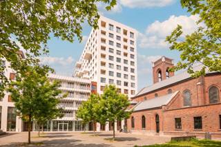 Op een indrukwekkende negende verdieping van een recent residentieel gebouw bevindt zich dit elegant appartement van ca. 110 m², aangevuld met een aangenaam terras van ca. 11 m². De uitzonderlijke ligging en hoogte staan garant voor een weids panoramisch uitzicht over Antwerpen, waarbij onder meer het MAS, de Onze-Lieve-Vrouwekathedraal en de Boerentoren het unieke stadsdecor bepalen.

Via de ruime inkomhal wordt de leefruimte bereikt, waar grote raampartijen zorgen voor een overvloed aan natuurlijk licht en een voortdurende connectie met de skyline van de stad. De open keuken sluit naadloos aan op de leefruimte en beschikt aansluitend over een praktische berging.

Het slaapgedeelte omvat twee ruime slaapkamers, een stijlvolle badkamer en een nachthal met afzonderlijk gastentoilet en extra bergruimte.

De afwerking combineert warme parketvloeren in de leef- en slaapvertrekken met onderhoudsvriendelijke tegelvloeren in de keuken en sanitaire ruimtes, wat het geheel een tijdloze en verzorgde uitstraling geeft.

Als verlengde van de leefruimte biedt het terras van ca. 11 m² een bijzondere buitenruimte waar men in alle rust kan genieten van het panoramische zicht over de stad.

Een privatieve parkeerplaats op niveau -3 is mee aan te kopen voor € 35.000.

Momenteel is het appartement verhuurd.

De residentie bevindt zich op een uitzonderlijke locatie tussen 't Eilandje en het historische stadscentrum. Deze stadsomgeving combineert een vlotte bereikbaarheid met een ruim aanbod aan winkels, restaurants, hotspots en culturele voorzieningen.
