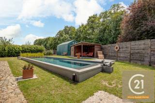 Droomt u van rust, ruimte en natuur, en dat op slechts een steenworp van alle voorzieningen? Dan is deze charmante villa op 2 percelen van samen 2.523 m² precies wat u zoekt. Deze prachtige woning is omgeven door groen en biedt volledige privacy dankzij de bomen rondom het domein — het voelt als een privébos waar u in alle stilte kunt wandelen en genieten van de natuur in uw eigen achtertuin.<br /><br />De woning beschikt over een prachtig zwemvijver met een stijlvolle loungehoek, perfect om te ontspannen of gasten te ontvangen bij een zomerse barbecue. Aansluitend aan de woning bevindt zich een ruime veranda met een panoramisch zicht op de uitgestrekte, perfect onderhouden tuin. Halverwege het perceel vindt u drie garages, ideaal voor het opbergen van tuinmateriaal of extra opslag.<br /><br />De villa biedt naast deze buitenpracht ook comfort en functionaliteit binnenin. Er zijn drie slaapkamers, waarvan twee op het gelijkvloers en één zeer ruime kamer op de verdieping — deze laatste kan makkelijk worden opgedeeld in twee aparte kamers. De recent gerenoveerde badkamer straalt luxe en moderniteit uit. In de leefruimte en master bedroom is airconditioning voorzien voor extra comfort. Verder is er een kelder, een tuinhuis, een carport aan de zijkant van de woning, én een atelier achter de garage — ideaal voor wie graag klust of creatief bezig is.<br /><br />Ook aan duurzaamheid werd gedacht: op het dak liggen zonnepanelen die bijdragen aan een lagere energiefactuur. Parkeren is geen enkel probleem dankzij de ruime oprit met plaats voor vier wagens en de dubbele inpandige garage.<br /><br />Deze unieke eigendom biedt een zeldzame combinatie van rust, ruimte, comfort en natuurbeleving, vlakbij het centrum van Machelen. Een buitenkans voor wie wil wonen in een oase van groen met alle comfort van een moderne woning.<br /><br />Voor meer info en foto's kijk op www.century21vilvoorde.be