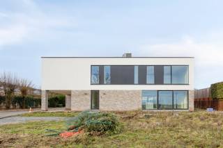 Nieuwbouw, hypermoderne en extreem energiezuinige (EPB A+ -43!) villa met liefst 5 slaapkamers (én mogelijkheid tot bijhuren van praktijkgedeelte). 📞 Interesse? Plan uw afspraak online op onze website (WWW.STRUCTURA.BE) of contacteer Structura voor meer informatie of een bezoek ter plaatse.Deze hedendaagse villa combineert strakke architectuur, ruimte en licht en is gelegen op een vlot bereikbare locatie. De woning werd ontworpen met oog voor comfort, functionaliteit en een open gevoel, en biedt een uitzonderlijke woonkwaliteit voor wie ruim en modern wil wonen.Op het gelijkvloers bevindt zich een indrukwekkende, lichtrijke leefruimte met grote raampartijen die zorgen voor een mooie connectie met de tuin(en) en het terras(sen). De open keuken sluit naadloos aan bij de leefruimte en vormt het hart van de woning. Naast de keuken bevindt zich een praktische keukenberging. Langs de achterzijde van de woning bereikt u via een aparte ingang het praktijkgedeelte dat is voorzien van een wachtzaal, WC, berging en praktijkruimte/bureau. Er zijn achteraan ook 2 staanplaatsen voorzien voor het praktijkgedeelte. Dit praktijkgedeelte is niet inbegrepen in de huurprijs, maar kan worden bij gehuurd aan €750/maand, wat de totale huur op €2.750/maand brengt.De verdieping omvat maar liefst vier volwaardige slaapkamers, elk voorzien van een eigen dressingruimte in de kamer. De master bedroom met dressing, is tevens voorzien van eigen stijlvolle douchekamer en bijkomende sanitaire voorzieningen. Op het verdiep bevindt zich nog een tweede douchekamer, een enorme polyvalente ruimte/2e living uitgevend op een zeer ruim balkon, én een 2e bergruimte. De indeling is logisch en doordacht, met aandacht voor privacy en comfort.Buiten geniet u van een privatieve tuin en terras langs weerszijde van de woning, ideaal om tot rust te komen of gasten te ontvangen. Er is parking voorzien voor 6 wagens + een carport. De architecturale lijnen en grote glaspartijen versterken het moderne karakter van de woning. Deze villa is ideaal voor wie op zoek is naar ruimte, licht, hedendaagse architectuur en wooncomfort, gecombineerd met een verzorgde en rustige woonomgeving.Verwarming via warmtepompen. EPB A+ -43 !! 3 maanden huurwaarborg. Onmiddellijk vrij. Huur voor professionelen mogelijk!📞 Interesse? Contacteer Structura voor meer informatie of een bezoek ter plaatse.