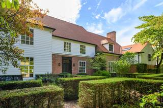 <p><span>Deze bijzonder ruime villa in Long Island-stijl is gelegen aan de Frilinglei, één van de meest gegeerde locaties van Brasschaat-Vriesdonk op een perceel van ca. 3.182 m²</span></p><p><span> </span></p><p><span>Indeling</span><span>: U betreedt de villa middels de ruime centrale inkomhal met vestiaire en gastentoilet. De natuurstenen vloer en brede zichtlijnen geven onmiddellijk een indruk van de royale volumes van de woning. Aan de voorzijde bevindt zich een afzonderlijke tv-kamer met maatwerkmeubilair. Aansluitend ligt de ruime woonkamer, welke werd ingericht met verschillende zitgedeeltes en een sfeervolle open haard. Grote raampartijen en schuifdeuren zorgen voor veel natuurlijk licht en geven rechtstreeks toegang tot de terrassen en tuin. De aansluitende eetkamer vormt een mooie verbinding tussen de woonkamer, ontbijtkamer en keuken. Ook hier zorgen de raampartijen voor een aangename relatie met het omliggende groen. De royale keuken werd ingericht met veel kastruimte en diverse inbouwtoestellen. Een afzonderlijke ontbijtkamer biedt ruimte voor dagelijks tafelen en geeft uit op het terras. Aansluitend bevinden zich een praktische bijkeuken en wasplaats.</span></p><p><span> </span></p><p><span>Inpandig zwembad</span><span>: Een bijzondere troef is het inpandige zwembad met grote raampartijen naar de tuin en vormt een private ontspanningsomgeving binnen de woning. Het inpandige zwembad werd nog niet gerenoveerd doch is functioneel. De afzonderlijke technische ruimte bevindt zich direct naast het zwembad en beschikt ook over een aparte toegangsdeur voor onderhoudspersoneel.</span></p><p><span> </span></p><p><span>Garages</span><span>: De villa beschikt over drie inpandige garages en een ruime, volledig verharde oprit met parkeergelegenheid voor meerdere wagens. Vanuit de garage heeft u toegang tot de kelder.</span></p><p><span> </span></p><p><span>Kelder</span><span>: De woning beschikt over een praktische kelder met bergruimte en wijnkelder. De villa is verder volledig voorzien van kruipruimte.</span></p><p><span> </span></p><p><span>Eerste verdieping</span><span>: De centrale trap leidt naar de ruime nachthal op de eerste verdieping. De royale mastersuite vormt een afzonderlijk en comfortabel geheel met een ruime slaapkamer, eigen dressing en een luxueus vernieuwde badkamer, stijlvol afgewerkt en ingericht met een vrijstaand ligbad, ruime inloopdouche, dubbele wastafel en toilet. Tevens een logeerkamer of bijkomende slaapkamer met eveneens een badkamer. Daarnaast bevinden zich op deze verdieping nog drie volwaardige slaapkamers en drie badkamers. De kamers beschikken over mooie volumes, natuurlijk lichtinval en diverse bergmogelijkheden. </span></p><p><span> </span></p><p><span>Tuin en buitenruimtes</span><span>: De villa wordt omgeven door een volwassen en bijzonder private tuin met uitgebreide tuinverlichting. De automatische toegangspoort, hoge hagen en volwassen bomen creëren een groen kader rondom de woning en waarborgen een hoge mate van rust en privacy. De tuin werd voorzien van een automatisch beregeningssysteem welke is aangesloten op een geboorde put van ca 70 meter diep. Aan de achterzijde zijn royale terrassen welke rechtstreeks aansluiten op de verschillende leefruimtes. De ruime oprit aan de zijkant van het eigendom biedt een discrete toegang tot de garages en bijkomende parkeergelegenheid.</span></p><p><span> </span></p><p><span>Bijzonderheden</span><span>: Deze villa werd gebouwd in 1988 door Vlassak-Verhulst met hoogwaardige en duurzame materialen en gerenoveerd in 2022. De woning biedt u royale leefruimtes, vijf slaapkamers, zes badkamers, een inpandig zwembad en drie garages en onderscheidt zich door haar Long Island-architectuur, bijzonder royale woonoppervlakte en flexibele indeling. Recent werden reeds verschillende renovatie- en opfrissingswerken uitgevoerd waarbij onder meer de volledige elektrische installatie werd vernieuwd, een uitgebreid KNX-domoticasysteem werd voorzien voor de intelligente aansturing van de woning, nieuwe toegangspoort en garagepoorten en werden de houten vloeren opnieuw geschuurd. Deze villa is een bijzonder eigendom op één van de mooiste locaties van Brasschaat-Vriesdonk.</span></p><p><span> </span></p><p><span>Meer inlichtingen via ons kantoor.</span></p>