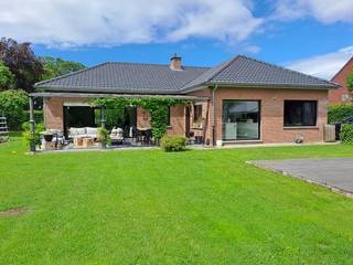 Volledig gerenoveerde woning gelegen in doodlopende straat. <br />Je betreedt de woning via de ruime inkomhal, deze geeft je toegang tot de lichtrijke ruime leefruimte en het privé gedeelte . De woonkamer wordt omringd door grote glaspartijen waardoor je gans het uitzicht geniet van de tuin en veel lichtinval ervaart.<br />De woonkamer geeft toegang tot de volledig geïnstalleerde keuken met kookeiland (2020). Aan de keuken werd een bureauruimte voorzien.<br />In de gang bevinden zich 3 ruime slaapkamers. Een volledig vernieuwde badkamer met dubbele lavabo, ligbad, douche (2023), een apart toilet (2025), een ingebouwde bergkast en een waskamer met valtrap - die toegang geeft tot de ruime zolder (2026).<br />De zolder is verspreid over gans de woon oppervlakte en biedt hiermee grote opbergruimte of andere mogelijkheden. De zolder en het dak werden in mei 2026 volledig vernieuwd en geïsoleerd. Het ventilatie systeem D werd ook op deze verdieping geïnstalleerd (2023)<br /><br />De grote (1240m²) Zuid gerichte tuin is volledig rondom de woning gelegen. De tuin is volledig omheind waardoor je geliefde viervoeter of kinderen vrij kunnen rondlopen! <br />De tuin beschikt over 2 Zuid gerichte terrassen waarvan 1 volledig overdekt. De tuin beschikt over veel speel en ontspanningsmogelijkheden, in de voortuin vind je een ingebouwde trampoline. De lange oprit biedt ruimte om minstens een 5 tal wagens te parkeren.<br />De dubbele garage is voorzien van 2 sectionaalpoorten, op dit dak liggen de recent geplaatste zonnepanelen (2023) <br />Er is een kruipkelder aanwezig over gans de woonoppervlakte. <br />BELANGRIJK! De woning is gelegen aan de spoorweg, vooraf even bij jezelf inchecken of je dit ziet zitten voor je een bezoek vraagt! <br /><br />Troeven:<br />-Laagbouwwoning<br />-Volledig gerenoveerd<br />-Dubbele garage<br />-Grote tuin<br />-Rustige buurt = een plek waar kinderen nog op de straat spelen<br /><br />Contactgevens: <br />Stephanie <br />0497/78.98.28<br /><br />Heel welkom! <br /><br />