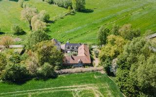<h3><span>FLOBECQ | Authentieke hoevewoning met atelier, schuur en 9.470 m² grond</span></h3><p><span>Bent u op zoek naar een karaktervolle hoevewoning op een uitzonderlijke locatie, met ruimte voor wonen, werken of een nieuw project? Dan is deze authentieke hoeve in Flobecq, waar stilte, ruimte en rust samenkomen, beslist een bezoek waard.</span></p><p><span>Achter de dubbele toegangspoort bevindt zich een sfeervol binnenhof, omringd door de drie vleugels van de hoeve. De eerste vleugel doet vandaag dienst als inspirerend kunstatelier: een indrukwekkende, open ruimte tot in de nok, met mezzanine, open haard en toegang tot de kelder. Een plek waar creativiteit alle ruimte krijgt.</span></p><p><span>In de centrale vleugel vindt u het hart van de woning: de gezellige leefruimtes met authentieke charme en open haard, de keuken, badkamer, slaapkamer en bergruimte. De derde vleugel omvat momenteel opslagruimtes, een veranda, wasplaats en technische ruimte. Ook de grote ruimtes op de verdieping wachten op een nieuwe invulling en kunnen volledig naar wens worden ingericht. Extra kamers, een gastenverblijf, een cohousingproject. </span></p><p><span>Naast de hoeve bevindt zich een imposante schuur vol potentieel voor hobby, opslag, ambachtelijke of professionele activiteiten.</span></p><p><span>Op een glooiend perceel van maar liefst 9.470 m² wisselen tuin, boomgaard, weide en bos elkaar af, met een uitzonderlijke vegetatie waaronder een majestueuze lindeboom. Dankzij de unieke ligging geniet u hier van maximale privacy, waar rust geen luxe maar een vanzelfsprekendheid is en elke dag als vakantie aanvoelt.</span></p><p><span>Deze eigendom is een levensstijl, een plek waar wonen, werken, creëren en genieten moeiteloos samenvloeien.</span></p><p><span>Troeven:</span></p><ul><li><span>Authentieke driegevel-hoeve met sfeervol binnenhof </span></li><li><span>Unieke landelijke ligging met absolute privacy </span></li><li><span>Atelier en grote schuur met tal van mogelijkheden </span></li><li><span>Perceel van 9.470 m² met tuin, weide en bos </span></li><li><span>Grotendeels vernieuwde en geïsoleerde daken </span></li><li><span>Potentieel voor co-housing, B&B, combi wonen-werken</span></li><li><span>Gelegen nabij wandel- en fietsknooppunten </span></li></ul><h3><span>Richtprijs: 995.000</span><span>.</span></h3>