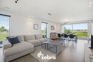 Deze instapklare kijkwoning met inpandige garage en vier slaapkamers bevindt zich in een rustige en aangename woonwijk aan de rand van Roeselare. Met haar moderne architectuur en stijlvolle uitstraling combineert de woning hedendaags wooncomfort met een groene en rustige omgeving, terwijl u toch geniet van een vlotte bereikbaarheid.<br /><br />Bij het binnenkomen komt u terecht in de inkomhal met apart gastentoilet. Aansluitend bevindt zich de ruime en lichtrijke leefruimte die naadloos overgaat in de volledig ingerichte keuken met kookeiland. De keuken is uitgerust met een vaatwasser, combi-oven, koelkast, kookplaat en dampkap. Verder beschikt het gelijkvloers over een inpandige garage.<br /><br />Op de eerste verdieping bevinden zich vier volwaardige slaapkamers, waaronder een ruime master bedroom met maatkasten. Daarnaast is er een ingerichte badkamer voorzien van een ligbad, doorloopdouche en dubbel lavabomeubel. Verder vindt u op deze verdieping nog een apart toilet en een praktische berging.<br /><br />De woning behaalt een uitzonderlijk laag E-peil van -7 dankzij de aansluiting op het stadswarmtenet, vloerverwarming en zonnepanelen van 5.600 WP.<br /><br />Tot slot beschikt de woning over een ruime tuin met terras, grenzend aan een groenzone. De woning wordt bovendien volledig bemeubeld verkocht.<br /><br />* Prijs excl. btw en kosten.<br /><br />Een vrijblijvend gesprek over dit project is mogelijk bij ons op kantoor.