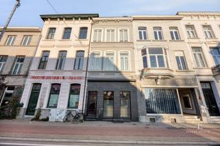 Op een uitstekende locatie nabij het centrum van Ledeberg bevindt zich dit statige herenhuis met een bewoonbare oppervlakte van maar liefst 275 m². De woning combineert authentieke elementen met een zeer ruime indeling en biedt daardoor tal van mogelijkheden, zowel voor grote gezinnen als voor wie wonen en werken wil combineren.<br /><br />Bij het betreden van de woning komt u terecht in een indrukwekkende inkomhal met authentieke trap en verschillende karaktervolle details zoals rozetten, moulures, parketvloeren en hoge plafonds. Op het gelijkvloers bevindt zich een aparte ruimte die perfect kan dienen als bureau of praktijkruimte, aangevuld met een kitchenette. Achteraan werd een ruime aanbouw voorzien waar zich de keuken, de leefruimte en een praktische berging met toilet bevinden. Dankzij de grote raampartijen geniet de woning van veel natuurlijke lichtinval. Verder zijn er twee gezellige stadskoeren aanwezig.<br /><br />Op de eerste, tweede en derde verdieping bevinden zich in totaal vier ruime slaapkamers en twee badkamers, wat deze woning bijzonder geschikt maakt voor grotere gezinnen of voor wie extra ruimte wenst.<br /><br />De ligging vormt een bijkomende troef: winkels, waaronder Delhaize, het centrum van Ledeberg, openbaar vervoer en belangrijke invalswegen bevinden zich in de directe omgeving. Ook met de fiets is de woning vlot bereikbaar dankzij de goede fietsverbindingen.<br /><br />Kortom, een karaktervolle en ruime stadswoning met enorm potentieel, ideaal voor vrije beroepen, zelfstandigen of gezinnen die op zoek zijn naar ruimte en charme op een centrale locatie.<br /><br />Interesse in deze woning? Contacteer voor meer informatie of een bezoek via +32 75 20 18 05.