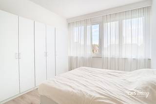 Ontdek dit zonnige appartement op de tweede verdieping van een kleinschalig gebouw. Geniet direct van bewoonbaar comfort met een ruime hal die uitnodigt naar de gezellige woonkamer, gekenmerkt door een warme laminaatvloer en dubbele beglazing. De open keuken is volledig uitgerust met top apparaten van Smeg (Koelkast, vriezer, oven en gasvuur). De ruime slaapkamer (ca. 15m²) biedt een prachtig uitzicht op de serene stadstuinen. De badkamer is voorzien van een bad/douche en een wastafelmeubel. Een gastentoilet is voorzien in de hal. De tweede slaapkamer (ca 9m²) biedt toegang tot het gezellige terras met avondzon. In de kelder zijn er nog twee bergingen voorzien. Condenserende ketel aanwezig (2022). Elektriciteit conform.