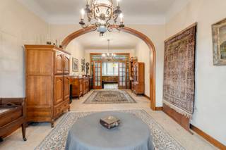 Deze interbellumwoning uit 1938 is een unieke combinatie van authentieke uitstraling, een groene omgeving en een bijzonder centrale ligging. De woning bevindt zich in het centrum van Aalst, op een aangename en rustige locatie met veel groen, terwijl het station, het stadscentrum en verbindingswegen zoals de E40 vlot bereikbaar zijn. De woning beschikt over karaktervolle authentieke elementen, waaronder hoge plafonds en sfeervol glas-in-lood. De ruime leefruimte vormt het hart van de woning en sluit rechtstreeks aan op de keuken, waardoor een aangename en open leefomgeving ontstaat. Verder beschikt de woning over vier slaapkamers en één badkamer. De woning is volledig onderkelderd en biedt niet alleen ruime bergruimte, maar doet bovendien dienst als ruime garage. De woning is te moderniseren en biedt daardoor volop mogelijkheden om ze volledig naar eigen smaak en comfort in te richten, met respect voor de architectuur en karaktervolle elementen van de woning. Een extra troef is de mogelijkheid tot aankoop van de naastliggende bouwgrond van 2a 32ca. Deze extra oppervlakte biedt interessante mogelijkheden voor wie nood heeft aan een ruime tuin, extra buitenruimte of bijkomend potentieel zoekt.
Een bijzonder pand voor wie houdt van karakter, ruimte en authenticiteit en tegelijk wil genieten van een rustige, groene ligging in het hart van Aalst, met het station, het centrum en de E40 vlakbij. Wenst u meer informatie of een bezoek? Stuur gerust een mail naar Louis@immoaccenta.be