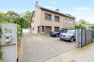Deze ruime halfopen bebouwing met een bewoonbare oppervlakte van ca. 260 m² biedt bijzonder veel ruimte en mogelijkheden. Via de toegangspoort bereik je de grote oprit en dubbele garage, ideaal voor meerdere wagens en extra bergruimte.<br /><br />De inkomhal biedt rechts toegang tot de keuken en links tot een eerste leefruimte, een slaapkamer en een ensuite badkamer. Deze praktische indeling creëert heel wat mogelijkheden, zoals kangoeroewonen, comfortabel gelijkvloers wonen of de inrichting van een praktijk- of kantoorruimte voor een zelfstandig beroep.<br /><br />Verderop is er nog een apart toilet en een 2de, zeer ruime leefruimte met tal van mogelijkheden voor een gezellige zit- en eetruimte.<br /><br />Op de 1ste verdieping bevinden zich 2 slaapkamers, een grote badkamer en een praktische wasberging. De 2de verdieping beschikt over een zeer ruime zolderkamer, ideaal als 4de slaapkamer, bureau, hobby- of speelruimte.<br /><br />Buiten geniet je van een gezellige buitenruimte met overdekt loungegedeelte en achteraan een aangename groene omgeving.<br /><br />Een veelzijdige woning op een groene locatie met 4 slaapkamers, 2 badkamers, dubbele garage, veel parkeergelegenheid en ideaal voor een groot gezin, kangoeroewonen of een combinatie van wonen en werken.<br /><br />De naastgelegen bouwgrond kan optioneel mee aangekocht worden.<br /><br />Wij leiden je graag rond.