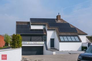 Ontvangstruimte met toonzaal/kantoren en kitchenette, grote vergaderruimte met bar, verschillende kantoorunits, woonst bestaande uit: Inkom, living, eetruimte, ingerichte keuken, 4 slaapkamers, dressing, 2 badkamers, sauna, dakterras met jacuzzi. Verder is er een zonnige tuin met ruim overdekt terras, zwemvijver, parking voor ca 8 wagens en ondergrondse garage voor 4 wagens. Verwarming via warmtepomp en PV installatie. Oppervlakte kantoorgedeelte ca 230m².