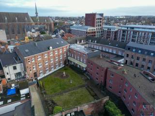 <p>In het hart van Sint-Truiden ligt dit bijzonder pand met een indrukwekkende omvang, een weergave van zowel architectonische schoonheid als historie.<br />Dit voormalig klooster van de Zusters Ursulinen dient een nieuwe bestemming te krijgen.<br />Een grondoppervlakte van 24a 95ca en meer dan 4.000 m2 bebouwde oppervlakte, omgeven door de charme van de historische stad, biedt heel wat mogelijkheden.<br />De huidige indeling en de veelzijdigheid van het gebouw stellen u in staat om vrij te fantaseren over de mogelijkheden die hier liggen, van culturele ruimtes tot inspirerende woonconcepten.</p>
<p>De mogelijkheden voor duurzame renovaties zijn eindeloos, wat het pand een ideale investering maakt. Dit is meer dan alleen een gebouw; het is een kans om een hoofdstuk toe te voegen aan de geschiedenis van deze stad!<br /><br />Reeds in de 13de eeuw bouwde de abdij van Averbode een refugiehuis in Sint-Truiden. Het huidige complex gaat terug tot de 16de eeuw en werd stelselmatig uitgebreid tot een vierkant complex met centrale binnentuin.<br /> <br />Historiek:<br /><br />De stichting van het refugiehuis van de abdij van Averbode klimt op tot de 13de eeuw. Van dit eerste gebouw bleef echter vrijwel niets bewaard.<br />In 1555 werd een nieuw refugiehuis gebouwd op de hoek van de Clockemstraat en Sluisberg. Het oudste deel is de huidige oostvleugel van het complex. De noordgevel van deze oostvleugel was oorspronkelijk de voorgevel. Het gebouw werd stelselmatig uitgebreid met verschillende vleugels.<br />Zo ontstond uiteindelijk een vierkant complex met een centrale binnenkoer. De zuidvleugel werd opgetrokken in 1598.<br />Voor 1794 was het goed reeds in privaat bezit overgegaan en was het de eigendom van de familie Roberti. Sinds 1864 wordt het complex betrokken door de zusters ursulinen. Eind 19de, begin 20ste eeuw voegden de zusters de overige gebouwen toe in de<br />Ursulinenstraat en in Sluisberg.<br />De oorspronkelijke ingang bevond zich in de noordelijke zijgevel; een muur, in de richting van de Grote Markt sloot het pand af aan de oostzijde.<br />In 1927 werd hier een gebouw met torentje bijgevoegd, opgetrokken in neotraditionele stijl.<br /><br />Beschermingsstatuut:<br /><br />Clockemstraat 5:<br />Vastgestelde Inventarissen:<br />Historische stadskern van Sint-Truiden (Vastgestelde archeologische zone)<br />Refugiehuis van de abdij van Averbode (Vastgesteld bouwkundig erfgoed)<br />Unesco Werelderfgoed:<br />Stadhuis Sint-Truiden met belfort: buffer (UNESCO werelderfgoed bufferzone)<br />Plannen:<br />Haspengouw en Voeren - Hoogstamboomgaarden (Onroerenderfgoedrichtplan)<br />Wetenschappelijke Inventarissen:<br />Historische stadskern van Sint-Truiden (Archeologisch geheel)<br />Refugiehuis van de abdij van Averbode (Bouwkundig element)<br />Clockemstraat 5a:<br />Beschermd Onroerend Erfgoed:<br />Refugiehuis abdij van Averbode (Monument)<br />Vastgestelde Inventarissen:<br />Historische stadskern van Sint-Truiden (Vastgestelde archeologische zone)<br />Refugiehuis van de abdij van Averbode (Vastgesteld bouwkundig erfgoed)<br />Unesco Werelderfgoed:<br />Stadhuis Sint-Truiden met belfort: buffer (UNESCO werelderfgoed bufferzone)<br />Plannen:<br />Haspengouw en Voeren - Hoogstamboomgaarden (Onroerenderfgoedrichtplan)<br />Wetenschappelijke Inventarissen:<br />Historische stadskern van Sint-Truiden (Archeologisch geheel)<br />Refugiehuis van de abdij van Averbode (Bouwkundig element)<br /><br />Dit unieke pand wordt verkocht via het COVAST platform, de startprijs bedraagt 1.988.750,00. Voor meer informatie over de biedingsprocedure kan u steeds contact met ons opnemen.</p>