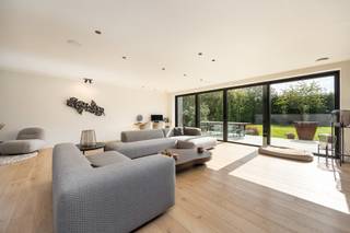 Deze gelijkvloerse villa in Aartselaar ligt op een perceel van 1.593 m² en combineert een ruime woning met een groot magazijn. De woning heeft een open indeling, grote glaspartijen en veel natuurlijk licht.<br /><br />Via de inkomhal met grote glazen deur kom je binnen in de woning. Hier bevinden zich een ingemaakte vestiaire en een gastenwc met smart-toilet. De ruime eetkamer sluit aan op de woonkamer met zicht op de tuin. De volledig uitgeruste keuken is voorzien van inbouwtoestellen en sluit aan op een technische berging.<br /><br />De master bedroom beschikt over een geïntegreerde badkamer met ligbad en dubbele regendouche én een volledig ingebouwde dressing met wasruimte. De tweede slaapkamer heeft eveneens een eigen badkamer met douche.<br /><br />Verder beschikt de woning over vloerverwarming, domotica, geïntegreerd geluidsysteem en een conforme elektrische installatie.<br /><br />Buiten is er een aangenaam terras en een volwassen, groen aangelegde tuin (zwembad mogelijk). Aan de woning is er een oprit met plaats voor drie wagens en een laadpaal.<br /><br />Naast de villa bevindt zich het ruime magazijn, voorzien van een toilet en douche. Het magazijn beschikt ook over een verdieping, wat extra opslag- of werkruimte biedt. De ruime oprit (circa 180m²) aan het magazijn zorgt voor voldoende manoeuvreerruimte.<br /><br />Extra troeven:<br />- Gelijkvloerse villa<br />- Perceel van 1.593 m²<br />- Ruim magazijn met verdieping<br />- Ruime oprit aan het magazijn<br />- Oprit aan de woning voor drie wagens<br />- Laadpaal<br />- Twee slaapkamers met elk een eigen badkamer<br />- Grote glaspartijen<br />- Aangename tuin en terras<br />- Mogelijkheid tot zwembad<br />- Vloerverwarming<br />- Domotica<br />- Surround geluidssystemen<br />- Conforme elektrische installatie<br />- 20 zonnepanelen<br />- EPC A (BEN-woning met E-peil van 21)<br />- Enkele jaren vrijgesteld van onroerende voorheffing<br />- Aanwezige camerabewaking, zonder abonnement<br /><br />Graag meer info of een bezoek gewenst?<br />Contacteer ons via 0492 83 88 19 of jarno@groepvanhaute.be