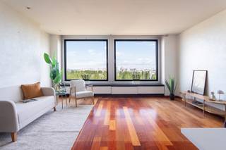 Dit appartement is gelegen in de rustige en residentiële Esmoreitlaan op Linkeroever, in de Habitim Tower. Vanuit deze locatie woont u in een groene omgeving, maar toch vlak bij het centrum van Antwerpen. De Schelde, de wandeldijk en het Sint-Annastrand bevinden zich op wandelafstand, ideaal voor een ontspannende wandeling of fietstocht. Ook winkels, scholen en openbaar vervoer zijn vlot bereikbaar. De hoge ligging van het appartement zorgt daarnaast voor een prachtig uitzicht over de Schelde en de skyline van Antwerpen. Dit aangename appartement bevindt zich op de twaalfde verdieping van de Habitim Tower. De ruime leefruimte van 33 m² is afgewerkt met een parketvloer en geniet dankzij de grote raampartijen van een aangename lichtinval. De keuken sluit aan op de leefruimte en is uitgerust met de nodige toestellen. Het appartement beschikt over twee slaapkamers van respectievelijk 16,5 m² en 10 m², beide voorzien van een laminaatvloer. Vanuit beide slaapkamers heeft u toegang tot het ruime terras van 13,5 m². Dankzij de elektrische zonneluifel kunt u hier op zonnige dagen aangenaam vertoeven en volop genieten van het prachtige uitzicht. De badkamer beschikt over een ligbad en een dubbele lavabo. Het toilet is apart en voorzien van een handenwasser. Daarnaast beschikt het appartement over een privatieve kelderberging, ideaal als extra opbergruimte.