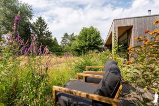 <strong>Prachtig, doordreven gerenoveerde woning in rustige residentiële buurt, nabij natuurgebied Keiheuvel. Deze unieke woning, gelegen op een perceel van 1.730 m², beschikt over een buitengewoon charmante, organische bloementuin met verschillende schaduw- en zonneterrassen en vijverpartij. Bij aanleg werd gefocust op biodiversiteit; er bevinden zich zowel inheemse flora als exoten, gericht op het aantrekken van vlinders. De villa zelf toont een verrassend staaltje architectuur en is bijzonder kwaliteitsvol afgewerkt en gemoderniseerd (o.a. middels grote uitbouw, maar ook energetisch). De woning met maar liefst 240m² bewoonbare opp. (excl. kelder), biedt 3 à 4 slaapkamers (waarvan 1 benedenslaapkamer), ruime badkamer met dressing en centrale leefruimte onder hoog plafond (ca. 3m) die als centraal element de verbinding maakt tussen de buitenomgeving en de binnenruimten.<br /><br />De indrukwekkend stijlvolle woning ademt klasse, charme, karakter en rust. De harmonie tussen de gebruikte materialen, de natuurtuin en de grote lichtrijke leefruimte met over de volledige lengte hoge raampartijen, zorgen voor een fascinerende beleving van licht en ruimte. De woning is volledig instapklaar en uiterst energiezuinig (EPC-score van 156 kWh/m²/jaar - label B): zonnepanelen, zonneboiler, hoogenergetische DDG-kachel, hoogrendementsglas, etc.<br /></strong><strong><br /></strong><em>Gelijkvloers - Inkomhal, leefgedeelte &amp; benedenslaapvertrekken</em><br /><br />De inkomhal met vestiairehoek en inbouwboekenwand als blikvanger geeft - via de benedennachthal - toegang tot woonkamer en leefkeuken. De open leefruimte is enorm lichtrijk door de glazen gevel met zicht op de tuin (brede hoge raampartijen; volledige kamerlengte); zij is langwerpig van opzet en hoogwaardig afgewerkt. Zij is ingedeeld in een zit- en eetgedeelte en geniet van een rustgevende, stijlvolle atmosfeer. <br /><br />Het keukengedeelte zelf is voorzien van werkruimte langs weerszijden en afgewerkt met design kraanwerk; zij is tevens uitgerust met ijskast, combi-oven, vaatwasmachine, inductiefornuis en voldoende schuif- en kastruimte.<br /><br />Het houtwerk binnen en buiten (riante dakoversteken), de glaspartijen, moderne verlichtingselementen en het strakkere, witte keukenontwerp contrasteren op verrassend evenwichtige wijze met de organische buitenomgeving en het karakter van het oorspronkelijke pand.<br /><br />De aansluitende eetplaats, afgescheiden van de keuken met stijlvolle, houten inbouwkastelement, doet dienst als centrale schakel tussen zithoek en keukenvertrekken. Mudroom, technische ruimte en gastentoilet zijn naastgelegen.<br /><br />Op het gelijkvloers is verder een benedenslaapkamer, privaat gelegen en met toegang tot de tuin. Aangrezend is een inloopdressing voorzien. De badkamer - tijdloos en hoogwaardig afgewerkt - beschikt over een lavabodeel (kamerbreedte), inloopdouche, toiletruimte en inbouwkastruimte (o.a. wasmachine). <br /><br /><em>(Tussen)verdiep - slaapkamers; multifunctioneel gebruik</em><br /><br />Op het tussenverdiep bevindt zich een extra kamer die thans dienst doet voor opslag maar om te vormen is tot slaapkamer of bureau. <br /><br />Op de bovenverdieping zijn 2 slaapkamers gelegen, waarvan 1 met ruime bijkamer. Dit verdiep kan polyvalent ingezet worden; bv. als thuiskantoor, hobbyruimte of studio.<br /><br /><em>Buitengebeuren - Tuin &amp; duurzaamheid</em><br /><br />De omheinde natuurtuin is organisch aangelegd met hoge heggen, bomen en heesters voor privacy. Er bevinden zich fruitbomen (appel, peer, kers) en een vijverpartij achteraan. Er is ruimte voor moestuin; tuinhuis en serre zijn aanwezig (op aanvraag). Verschillende zithoeken en terrassen bieden rustplaats; waaronder het hoofdterras op zuidwesten, voorzien van schaduw door specifiek opgekweekt en gesnoeide dakplataan. <br /><br />Zonnepanelen en -collectoren voorzien in hernieuwbare energie. Langzij de woning is er toegang tot de achtertuin (bv. voor aanhangwagen).