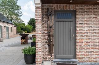 In het groene Tessenderlo, op een zuidgericht perceel van 26 are 76 ca, bevindt zich deze ruime en verzorgde gezinswoning, gerenoveerd in 2021, met een mooie combinatie van wooncomfort, privacy en extra leefruimte.<br /><br />De woning werd ontworpen met het dagelijkse gezinsleven in gedachten, maar biedt tegelijk die extra’s die haar net dat bijzondere karakter geven. Zo beschikt ze over een ruime inkomhal, een gezellige leefruimte en een luxueus uitgeruste keuken met hoogwaardige Siemens-toestellen en een Quooker-kraan. Aansluitend zijn er een praktische bijkeuken, wasplaats en een afzonderlijk bureel.<br /><br />In de hoofwoning zijn er vier slaapkamers en twee badkamers, met als absolute blikvanger de ruime mastersuite, compleet met eigen badkamer en dressing.<br /><br />Een bijzonder praktische aanvulling is het aparte gastenverblijf, met twee slaapkamers, een badkamer en een keuken. Hierdoor is er alle ruimte voor familie, vrienden en gasten.<br /><br />Daarnaast beschikt de woning over een wellnessruimte met inpandig zwembad en douche, ideaal voor wie graag thuis kan ontspannen en sporten.<br /><br />Ook voor autoliefhebbers biedt deze eigendom heel wat mogelijkheden. De woning beschikt over een dubbele inpandige garage met glazen deuren, aangevuld met een ruime oprit en carports. Er is bijgevolg voldoende plaats voor meerdere wagens.<br /><br />De ligging in Tessenderlo combineert rust en bereikbaarheid. Via de E313 en E314 zijn onder meer Hasselt, Geel, Diest en Leuven vlot bereikbaar, terwijl ook Antwerpen en het Leuvense en Limburgse hinterland eenvoudig binnen bereik liggen. De regio vormt bovendien een natuurlijke verbinding tussen Hageland, de Kempen en Limburg.<br /><br />De woning beschikt over een energiescore ‘B’, met 48 zonnepanelen en een thuisbatterij.<br /><br />Een royale gezinswoning met een warm karakter, een volwaardig gastenverblijf, eigen wellness en uitzonderlijk veel parkeermogelijkheden. Een huis dat niet alleen ruimte biedt om te wonen, maar ook om volop van het leven te genieten.