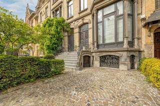<p><span>BERCHEM - Cogels-Osylei</span><span>: Eclectische herenwoning “De Zwaluwen” met 6 slaapkamers, 3 badkamers, groot bureau, oprit en zuidtuin. </span></p><p><span> </span></p><p><span>Een uitzonderlijke opportuniteit voor liefhebbers van karaktervolle architectuur, erfgoed en stijlvol wonen in de stad. </span></p><p><span> </span></p><p><span>Gelegen aan de iconische Cogels-Osylei bevindt zich deze beschermde karaktervolle herenwoning uit 1904 naar ontwerp van architecten Cols en Defever. Een uniek stukje Antwerpse geschiedenis in het hart van de gegeerde historische wijk Zurenborg. De Cogels-Osylei geldt als het prestigieuze visitekaartje van de wijk en staat bekend om haar indrukwekkende eclectische architectuur, monumentale gevelrijen en uitzonderlijk goed bewaarde belle-époque uitstraling.</span></p><p><span>Wonen op de Cogels-Osylei betekent wonen in één van de mooiste straten van Antwerpen, op wandelafstand van station Berchem, hippe horecazaken, gezellige pleinen en alle stedelijke voorzieningen. De wijk combineert architecturale grandeur met een levendige, residentiële sfeer.</span></p><p><span> </span></p><p><span>BESCHRIJVING:</span></p><p><span> </span></p><p><span>Gelijkvloers</span><span>:</span></p><p><span>Voortuin met oprit en trappen naar het residentiële en professionele gedeelte.Inkomhal op marmer met vestiaire en gastentoilet. Toegang tot de zeer lichte en prachtige living met hoge plafonds en authentieke moulures en schouw. Aanpalende bibliotheek en formele eetplaats. Keuken met eethoek en via prachtige ramen toegang tot het terras en zuidgerichte tuin.</span></p><p><span> </span></p><p><span>Verdiepingen</span><span>: </span></p><p><span>Masterbedroom met open haard, aanpalende dressing met ingemaakte kasten en en-suite badkamer. Verder vinden we nog 5 ruime slaapkamers en 1 tot 2 badkamers.</span></p><p><span> </span></p><p><span>Kelder</span><span>:</span></p><p><span>Polyvalente open ruimte ingericht als kantoor voor vrij beroep in 3 verbonden bureauruimtes met directe toegang aan de straatkant, met op maat gemaakte kasten en bibliotheek en lavabo. Toegang tot terras via schuifdeuren.</span></p><p><span> </span></p><p><span>BIJZONDERHEDEN:</span></p><p><span> </span></p><p><span>*Unieke architectuur op historische toplocatie</span></p><p><span>*Enorm potentieel en behoud van karaktervolle elementen</span></p><p><span>*Mooie zuidgerichte tuin</span></p><p><span>*Oprit</span></p><p><span>*Ideale combinatie wonen/werken</span></p><p><span> </span></p>