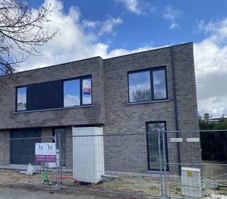 Deze nieuwbouwwoning is gelegen in Hospitaalstraat in Ertvelde en is gerealiseerd met een <strong>strakke, tijdloze architectuur</strong> die meteen in het oog springt. Bij het binnenkomen word je verwelkomd in een <strong>aangename inkomhal</strong> met apart toilet en een <strong>praktische bureauruimte</strong>, ideaal voor thuiswerk of hobby. De<strong> lichtrijke woonkamer</strong> sluit naadloos aan op het terras en de tuin en vormt samen met de prachtig, uitgeruste keuken het hart van de woning. Verder vind je op het gelijkvloers een <strong>inpandige garag</strong>e en een ruime <strong>wasplaats/berging</strong>, zodat alles perfect georganiseerd blijft.<br /><br />Op de verdieping wachten<strong> vier volwaardige slaapkamers</strong>, waaronder een <strong>master bedroom met ingemaakte dressing</strong>, een technische berging, een apart toilet en een luxueuze badkamer met zowel bad als douche. De woning wordt tot<strong> in de kleinste details afgewerkt</strong> met kwalitatieve materialen, ingemaakte kasten, een elegante glazen deur en een keuken die zowel praktisch als esthetisch uitblinkt.<br />De woning blinkt ook uit in energiezuinigheid dankzij de <strong>zonnepanelen</strong>, een <strong>lucht/water warmtepomp</strong> en moderne technieken. <br /><br />Gelegen op een perceel van <strong>333m² </strong>biedt deze nieuwbouwwoning niet alleen ruimte en licht, maar ook duurzame woonkwaliteit voor de toekomst. Bovendien kan de woning aangekocht worden aan het <strong>verlaagd BTW-tarief van 6%</strong> (onder voorwaarden), wat dit project extra aantrekkelijk maakt.<br /><br />Meer weten? info@vastgoedminnaert.be of <strong>09 330 61 04</strong>