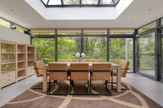 <p>Bij het betreden van deze <strong>charmante villa</strong> wordt u verwelkomd in een ruime inkomhal met gastentoilet. Vanuit de hal wandelt u door naar de lichtrijke leefruimte waar openheid en comfort centraal staan. De volledig geïnstalleerde open keuken is uitgerust met <strong>kwalitatieve toestellen van Miele</strong>, waaronder een inductiekookplaat, twee combi-microgolfovens, koelkast, vriezer, vaatwasser en een Quooker kraan. De eetruimte geniet van een prachtig zicht op de <strong>groene, volledig omheinde tuin</strong> en biedt directe toegang tot het <strong>riante terras van ca. 60 m²</strong>, afgewerkt met een sfeervolle fontein. Op het gelijkvloers bevinden zich verder een ruime slaapkamer, een bureauruimte dat perfect als vierde slaapkamer kan dienen en een verzorgde badkamer met ligbad, douche, lavabo en toilet. De eerste verdieping bevat nog twee volwaardige, lichtrijke slaapkamers en een tweede badkamer voorzien van douche, lavabo en toilet.</p><p>Een absolute meerwaarde is de <strong>volledig onderkelderde verdieping/garage</strong> van maar liefst <strong>220 m²</strong>. Deze biedt <strong>tal van mogelijkheden</strong>, zoals parkeergelegenheid voor maar liefst 5 auto's en beschikt bovendien over een extra badkamer met douche en lavabo, evenals aansluitingen voor wasmachine en droogkast.</p><p>Extra troeven:<br />- Energiezuinig met <strong>EPC-score B</strong> (154 kWh/m²/jaar), <strong>elektriciteit conform</strong>, <strong>asbestveilig</strong><br />- Perceelscore A en gebouwscore A<br />- Niet gelegen in overstromingsgevoelig gebied<br />- Gelegen in woonparkgebied, Gvkr, verdere stedenbouwkundige informatie in aanvraag<br />- Uitgerust met alarmsysteem en videobewaking</p><p><span><span>Nabij school, winkels, autosnelweg, openbaar vervoer, etc. Voor meer info ga naar www.coenenvastgoed.be of bel 03/375.82.92</span></span></p>
