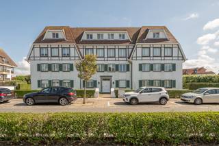 <span>Prachtige hoekappartement van ca. 130 m², gelegen in een exclusieve villaresidentie in het hart van het Zoute, op wandelafstand van het strand, de zee en de mooiste wandel- en fietspaden. Dankzij de hoekligging geniet het appartement van een overvloed aan natuurlijk licht en een aangenaam gevoel van ruimte. De royale leefruimte omvat een gezellige zithoek, een eethoek met open haard en een volledig geïntegreerde keuken. Vanuit de woonkamer heeft u toegang tot het zonnige, zuidgerichte terras, waar u in alle rust kunt genieten van een open uitzicht op het groen en de karaktervolle villaresidenties van het Zoute. Het appartement beschikt over twee volwaardige slaapkamers, elk voorzien van een eigen badkamer. Verder beschikt het appartement over een privatieve kelderberging en de mogelijkheid tot het aankopen van een dubbele garage in de residentie</span>