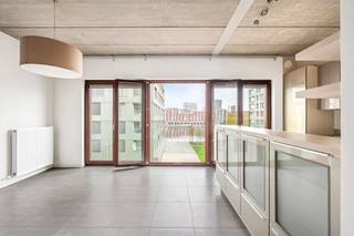 Op een toplocatie op het Antwerpse Eilandje bevindt zich dit uitzonderlijk loftappartement in een karaktervol brutalistisch gebouw. Het zichtbare betonnen plafond geeft het interieur een krachtige, architecturale uitstraling die perfect samengaat met de strakke lijnen en het overvloedige natuurlijke licht.<br /><br />Het appartement is energetisch doordacht gebouwd en biedt een uiterst flexibel grondplan: alles kan perfect als één open, loftachtige ruimte worden ingericht. De volledig geïnstalleerde keuken sluit naadloos aan op de eetkamer en woonkamer, die samen genieten van een prachtig zicht op het water — een dagelijks gevoel van rust en ruimte.<br /><br />Ruime slaapkamer en badkamer met ligbad en douche. Gezellig terrasje met namiddag en avondzon!<br /><br />Parking faciliteit in de buurt.