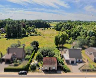 Deze bouwgrond van 887 m² voor open bebouwing heeft een straatbreedte van maar liefst 20 meter, is zuid-gericht en dit met een blijvend open zicht zowel naar voor als naar achter. Deze bouwgrond is vrij van aannemer en hier kan u bouwen tot maximum 1000m³ volume aan 6% btw na afbraak van de bestaande kleine woning. De bouwgrond is bovendien gelegen op 2km van de R4. <br /><br />Voor de sneller belsisser! <br />Referentie: 5671