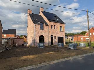 Energiezuinige woning met 5 slaapkamers
Deze energiezuinige woning biedt een praktische en ruime indeling met maar liefst 5 slaapkamers.
Op het gelijkvloers bevindt zich een inkomhal met apart toilet, die toegang geeft tot de ruime, open leefruimte. Deze omvat een gezellige zithoek, eetkamer en een volledig geïntegreerde open keuken. Aansluitend bevindt zich een berging. Vanuit de berging is de inpandige garage bereikbaar. Via de garage heeft u rechtstreeks toegang tot de praktische wasplaats.
Op de eerste verdieping bevinden zich 3 slaapkamers, een badkamer voorzien van een dubbele wastafel, een douche en een ligbad, en een apart toilet.
De zolderverdieping is bereikbaar via een vaste trap en beschikt over 2 bijkomende slaapkamers. Daarnaast is er nog een ruime zolder en een extra bergzolder, bereikbaar via een luik, die ideaal is als bijkomende bergruimte.
Rondom de woning worden klinkers aangelegd, evenals een verharde toegang naar de garage. De tuin wordt aangelegd en ingezaaid met gras, waardoor u kunt genieten van een verzorgde en groene buitenomgeving.