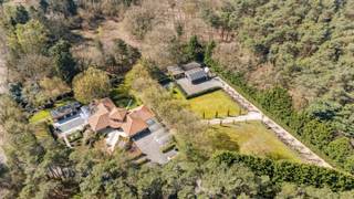 In een rustige en groene omgeving in Schoten bevindt zich deze ruime Spaanse villa op een royaal perceel van 8.670 m². Dit eigendom combineert karaktervolle architectuur met functionaliteit en tal van mogelijkheden, zowel privé als professioneel dankzij de aanwezigheid van een separaat gebouw.<br /><br />We parkeren onze wagens makkelijk op eigen terrein en hebben een ruime keuze; op een van de vele open parkeerplaatsen, onder de carport of in de garage.<br /><br />Via de ruime inkomhal betreedt u de lichtrijke leefruimte, voorzien van een gezellige houthaard en een ingebouwde bar – perfect voor gezellige avonden. <br />Aansluitend bevindt zich een ruime en stijlvolle bureau met ingebouwde kasten, ideaal als thuiskantoor.<br /><br />De leefkeuken is volledig uitgerust en beschikt over een kookeiland en ruime ontbijthoek die een prachtig uitzicht op de fraai aangelegde tuin en het uitnodigende zwembad biedt. <br />Aanpalend is er een ruime bijkeuken.<br /><br />Aan de andere zijde van de woning bevinden zich drie volwaardige slaapkamers en twee badkamers. Twee slaapkamers delen een moderne badkamer met douche, lavabo en toilet. De master bedroom beschikt over een eigen dressing en een ensuite badkamer met bubbelbad, dubbele lavabo en toilet – een ware privé-oase.<br /><br />Verder op het gelijkvloers vinden we een wasplaats, een inpandige garage, terwijl buiten een carport voorzien is voor drie wagens en voldoende open parkeerplaatsen.<br /><br />Buiten het gelijkvloers wonen herbergt de villa eveneens een afgewerkte eerste verdieping dewelke ingericht is als studio. Deze aparte studio beschikt over een eigen woonkamer, slaapkamer en badkamer – ideaal voor gasten, een au pair of als extra wooneenheid.<br /><br />In de tuin zijn twee ruime bijgebouwen ondergebracht.<br />Eén daarvan is ingericht als massagepraktijk bestaande uit een gelijkvloers gedeelte en ingerichte volwaardige kelderverdieping.<br />Het andere bijgebouw heeft een dubbele indeling; een gedeelte als berging en garage en een ander gedeelte is ingericht als yoga- en ontspanningsruimte.<br />Dit gebouw is tevens bereikbaar via een afzonderlijke toegang. Hierdoor blijft het privatieve gedeelte optimaal gescheiden van het beroepsgedeelte. <br />Beide gebouwen zijn perfect aanpasbaar aan persoonlijke of professionele noden.<br /><br />Tot slot biedt de woning nog een overdekt terras, een ruim zwembad en zonnepanelen en is deze volledig omheind. <br /><br />Een uniek eigendom die ruimte, privacy en veelzijdigheid moeiteloos combineert in een van de mooiste buurten van Schoten.<br /><br />Buitengewone kenmerken<br />- Groene omgeving<br />- Privacy<br />- Ruime villa en bijgebouwen<br />- Woon-werkcombinatie<br />- Veel lichtinval<br />- Aangename omgeving<br />- Zeer ruim perceel met twee toegangsmogelijkheden: privatief en zakelijk.