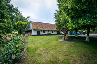 Compleet onttrokken aan de massa verschuilt dit landhuis met bijgebouwen in Engelse stijl zich in de geborgenheid & privacy van de eigen parktuin (7.222 m2). Deze omvat oa meerdere terrassen, zwemvijver met ponton, paviljoen, idyllische boomhut, Bbq, waterput, fruitboomgaarden, ... De lange opritlaan geflankeerd door een knappe lindenbomenrij zet onmiddellijk de toon bij het betreden van deze unieke architecturale eigendom met bekoorlijke binnen- en buitenomgeving. Het KLOEKE & ROBUUSTE profileert zich naadloos door het gebruik van zeer kwalitatieve materialen zoals natuursteen, veel maatwerk, houtwerk zoals oa deuren & trappen vervaardigd uit volle eik, lambrisering, balken voor de gaanderij en plafonds, verwarming met tegelkachels ...<br /><br />Het gelijkvloers hoofdwoning verdeelt zich in:<br />* Statige inkomhal met vestiaire & gastentoilet<br />* Leefruimte met eet- en zitkamer voorzien van een tegelkachel <br />* Volledig geïnstalleerde woonkeuken eveneens met een knappe tegelkachel met fornuis voorzien<br />* Bureel / slaapkamer<br />* Berging - wasruimte met extra pantry<br />* Gastenverblijf met leefruimte en bar voorzien van pelletkachel & slaapkamer op verdieping<br />* Feeëriek aangelegde parktuin met achterliggende vijver, boomhut & paviljoen<br /><br />Het bijgebouw bestaat uit:<br />* Garage & carport bijgaand met zeer ruime parking<br />* Atelierruimte met extra vliering<br /><br />Via de knappe eiken trap bereiken we de 1ste VD die omvat:<br />* Zeer ruime nachthal met zithoek<br />* 4 slaapkamers waarvan 1 met directe toegang tot de ensuite badkamer (hoekbad - wastafel)<br />* 1 badkamer (dubbele wastafel - inloopdouche - ligbad - toilet)<br /><br />De dakverdieping herbergt nog een zolderruimte die bereikbaar is via een uitschuifbare trap.<br /><br />EXTRA TROEVEN: Riant woonvolume / Meerdere bestemmingsmogelijkheden (B&B - Woon- werkcombinatie - Kangoeroewoning) / Exclusieve parktuin / Veel parkeergelegenheid / Volledige privacy /...