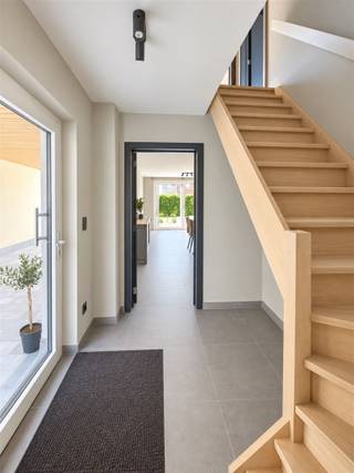 BIENVENUE DANS CETTE MAGNIFIQUE MAISON MODERNE À BELSELEIl s'agit d'une maison familiale contemporaine très attrayante, au design raffiné et aux finitions haut de gamme. La propriété se présente comme un joyau architectural, alliant harmonieusement une façade en briques et des annexes modernes en clinker blanc.EXTÉRIEUR ET AMÉNAGEMENT DU JARDINLa maison est entourée d’un joli jardin bien entretenu, avec des pelouses verdoyantes et des plantations élégantes. La maison dispose d’une terrasse spacieuse équipée d’un coin salon et d’un espace repas, idéale pour les loisirs en plein air et les moments conviviaux en famille ou entre amis. Un agréable patio agrémenté d’un parasol invite à la détente et à profiter du cadre.AGENCEMENT ET DISTRIBUTION DE L’ESPACEÀ votre arrivée, vous pénétrez dans un hall d’entrée très soigné, baigné de lumière naturelle grâce à de grandes baies vitrées. Un élégant escalier en bois mène à l’étage supérieur. Le rez-de-chaussée dispose d’une grande cuisine ouverte, parfaitement adaptée à la vie de famille moderne, avec un accès direct à la terrasse donnant sur le jardin.BLOC CUISINELa cuisine est équipée d’un impressionnant îlot central aux finitions noires et aux plans de travail dans des tons gris. Des placards aux teintes neutres offrent un vaste espace de rangement. De grandes baies vitrées coulissantes donnent sur le jardin et assurent une transition harmonieuse entre l’intérieur et l’extérieur.SALONLe salon attenant est très spacieux et offre tout le confort nécessaire à la vie de famille. Les revêtements de sol haut de gamme et l’éclairage par spots créent une ambiance moderne et raffinée. L’accès direct à la terrasse en fait l’endroit idéal pour passer des moments conviviaux.CHAMBRESLa maison dispose de trois chambres. L’une d’entre elles, la chambre parentale, dispose d’un accès à la terrasse et d’une vue dégagée ; elle est équipée d’une armoire encastrée moderne et d’un mur d’accent bleu vif qui lui confère du caractère. Une deuxième chambre offre un espace avec un bureau et un coin de travail privés, également dotés de grandes baies vitrées laissant entrer la lumière naturelle. La troisième chambre complète le logement.SALLE DE BAINSLa maison dispose d’une salle de bains entièrement équipée et au design moderne, avec une douche à l’italienne revêtue de carrelage gris, un double lavabo sur un élégant meuble noir et de grands miroirs. Un espace séparé est dédié à la baignoire, offrant une baignoire de luxe et des possibilités de détente illimitées. Des radiateurs sèche-serviettes et des équipements sanitaires haut de gamme viennent parachever cet espace privé.QUALITÉ DES FINITIONSPartout dans la maison, le souci du détail et de la qualité est clairement visible : un éclairage subtil, de belles peintures, des revêtements de sol aux couleurs neutres et des encadrements de portes rehaussés de touches noires créent un intérieur harmonieux et moderne.C’est une maison idéale pour les familles à la recherche de confort contemporain, d’espace et de style à Belsele.