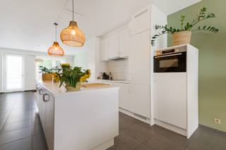Deze recente woning combineert een doordachte gezinsindeling met vier volwaardige slaapkamers, een aangename tuin en opvallend veel praktische ruimte. De Verbertstraat geniet van een centrale ligging in Schoten, op korte afstand van het centrum en het groene Gemeentepark. Winkels, scholen en dagelijkse voorzieningen bevinden zich vlakbij, terwijl ook het jaagpad langs het kanaal mooie wandel- en fietsmogelijkheden bieden. Zo combineert deze locatie een vlotte bereikbaarheid met verrassend veel groen en ontspanning in de onmiddellijke omgeving.<br /><br /><strong>Indeling</strong><br />Via de inkomhal met vestiairegedeelte en gastentoilet bereikt u de leefruimtes. Vooraan bevindt zich de eetkamer, terwijl de zithoek achteraan werd ondergebracht en zo een aangename, meer private plek vormt met zicht richting tuin.<br />Centraal ligt de geïnstalleerde keuken, die beide leefruimtes op een natuurlijke manier met elkaar verbindt. Zo ontstaat een praktische indeling waarbij koken, eten en ontspannen elk hun eigen plek krijgen, zonder het contact tussen de ruimtes te verliezen.<br /><br /><strong>Eerste verdieping</strong><br />De nachthal geeft toegang tot drie slaapkamers, waaronder een ruime hoofdslaapkamer aan de voorzijde. Verder bevinden zich hier de badkamer, een afzonderlijk toilet en een praktische wasplaats. Ook de technieken voor centrale verwarming en ventilatie werden netjes geïntegreerd.<br /><br /><strong>Zolder</strong><br />De volledig ingerichte zolderverdieping vormt een royale <strong>vierde slaapkamer</strong> en beschikt over ingemaakte kasten. Door de ruime oppervlakte kan deze verdieping desgewenst ook verder worden opgedeeld of gecombineerd worden met een bureau- of dressinggedeelte.<br /><br /><strong>Buitenruimte</strong><br />Achteraan beschikt de woning over een aangename tuin. Een bijkomende troef zijn de <strong>twee garages</strong>, die rechtstreeks via de tuin bereikbaar zijn en aan de achterzijde afzonderlijke toegang hebben via de Kalstraat, bijzonder praktisch voor parkeren, fietsen en extra bergruimte.<br />Onder de volledige woning bevindt zich bovendien een kruipruimte.<br /><br /><strong>Bijzonderheden</strong><br />Met <strong>vier slaapkamers, EPC B, twee garages en een recente bouwkwaliteit</strong> is dit een bijzonder complete woning voor wie ruimte, energiezuinigheid en dagelijks wooncomfort wil combineren.