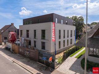 Exclusief woonproject in het centrum van Zandhoven:<br /><br />Voor wie ruim en luxueus wil wonen in de dorpskern, bieden wij dit nieuwbouwproject, Residentie Bruyneel, aan. Deze residentie combineert moderne luxe met functioneel design. Gelegen in het pittoreske Zandhoven, biedt dit project exclusieve woongelegenheid met hoogwaardige afwerking.<br /><br />Deze stijlvolle residentie telt 4 ruime luxe-appartementen en 1 exclusief dakappartement, telkens met een ruim zuid-gericht terras. De appartementen op het gelijkvloers hebben bovendien een mooie privatieve tuin. Achteraan het perceel zijn ruime privatieve autostaanplaatsen (2 per appartement waarvan 1 overdekt). Daar is ook een gemeenschappelijke fietsenberging voorzien. Ondergronds zijn er privatieve kelders. De aankoop van de autostaanplaatsen en een kelder is verplicht bij de aankoop van een appartement. <br /><br />Dit project is een realisatie van Struyf Building van Zandhoven, een gekend bedrijf die in de regio tal van referenties kan voorleggen. Het ontwerp is van de hand van architectenbureau Studio Noord, die andermaal voor een doordachte en stijlvolle architectuur hebben gezorgd. Elk appartement heeft ruime afwerkingsbudgetten en is uiteraard energiezuinig dmv het gebruik van een lucht-water warmtepomp, in combinatie met zonnepanelen. Het E-peil van deze appartementen ligt onder 20! <br /><br />De verkoop geschiedt onder BTW op de constructies (aankoop aan 6% BTW mogelijk, vraag naar de voorwaarden) en registratierechten op grondaandeel. Geen voorafgaande betalingen-volledige betaling bij oplevering van het appartement! Voor meer info of een verkennend gesprek, contacteer Karin 0486/97 84 27 of karin@reds.be.