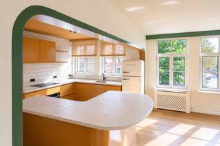 <p>In de levendige Sint-Andrieswijk, tussen het Zuid en het historische centrum van Antwerpen, bevindt zich dit bijzonder tweeslaapkamerappartement van ca 126 m². De hoekligging, royale raampartijen en doordachte renovatie zorgen voor een interieur dat meteen opvalt door zijn licht, ruimte en eigen karakter.<span></span></p>
<p>De leefruimte vormt zonder twijfel het hart van het appartement. Dankzij de vele ramen langs verschillende zijden valt het daglicht rijkelijk binnen en ontstaat er een aangename openheid doorheen de ruimte. De warme houten vloer vormt een rustige basis voor de uitgesproken keuken, waar gedurfde kleuren en organische lijnen voor een speels architecturaal accent zorgen. Het afgeronde werkblad vloeit bijna als een meubelstuk door in de leefruimte en creëert tegelijk een leuke plek om te zitten of te ontbijten. De keuken is volledig uitgerust met de nodige inbouwtoestellen waaronder retro SMEG koelkast en diepvriezer, combi-oven, vaatwasser en kookplaat.</p>
<p>Ook in de slaapvertrekken werd dezelfde aandacht aan materiaal en vorm doorgetrokken. De hoofdslaapkamer beschikt over een grote wand met ingemaakte kasten en een eigen badkamer met ligbad, douche, toilet en lavabomeubel. De tweede ruime slaapkamer geniet eveneens van een ensuite badkamer met douche en lavabo. Zachte, minerale afwerkingen, afgeronde vormen en zwarte accenten geven beide badkamers een rustige maar uitgesproken uitstraling.</p>
<p>De indeling is bovendien bijzonder comfortabel: beide slaapkamers beschikken over hun eigen badkamer en liggen afgescheiden van de leefruimte, waardoor wonen en slapen mooi van elkaar worden gescheiden.</p>
<p>Tot slot beschikt het appartement over een afzonderlijk gastentoilet en een ruime berging met aansluiting voor wasmachine en droogkast. Een privatieve kelderberging is eveneens inbegrepen.</p>
<p>Een inpandige autostaanplaats wordt mee aangeboden voor 65.000 Euro.</p>