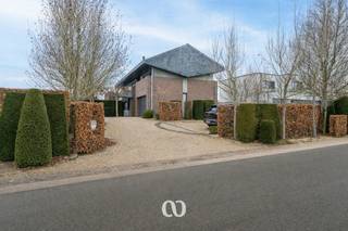 Ben jij op zoek naar een karaktervolle woning met een uitgesproken architectuur, veel ruimte en een uitzonderlijke ligging aan de rand van de Vlaamse Ardennen? Gevonden!<br /><br />Aan de rustige Wolvenberg in Oudenaarde vinden we deze unieke woning terug, ontworpen door architect Luc De Vriendt en gebouwd in 1981. De woning bevindt zich op een prachtig perceel van ruim 1.600 m² en geniet van een groene, residentiële omgeving met maximale privacy en rust.<br /><br />Wat deze woning meteen onderscheidt, is haar doordachte architectuur. De speelse dakstructuur, het gebruik van robuuste materialen en de sterke lichtinval zorgen voor een bijzonder aangename woonbeleving. Grote raampartijen, open zichtlijnen en slimme niveauverschillen creëren een woning die zowel ruim als gezellig aanvoelt.<br /><br />INDELING:<br />Je komt de woning binnen via de inkomhal met vestiaire en gastentoilet. Van hieruit heb je toegang tot de open leefruimtes, bestaande uit een lichtrijke living met zicht op de tuin, een aparte eetruimte en een keuken die rechtstreeks in verbinding staat met het terras. Verder vinden we op het gelijkvloers nog een praktische berging, een extra bergruimte met buitendouche en een ruime dubbele garage.<br /><br />Tussen het gelijkvloers en de slaapverdieping bevindt zich een tussenniveau dat ingericht is als bureau, ideaal voor thuiswerk of hobbyruimte.<br /><br />Op de eerste verdieping zijn er vier volwaardige slaapkamers, een badkamer en een aparte berging. In deze berging zijn alle voorzieningen aanwezig om eventueel een tweede badkamer te creëren.<br /><br />TUIN:<br />De tuin is een absolute troef en vormt een mooi verlengstuk van de woning. Dankzij de slimme aanleg geniet je hier van verschillende terrassen, open graspartijen en veel groen. Het grote houten terras nodigt uit om in alle rust te genieten van lange zomeravonden, met een prachtig uitzicht op de omgeving.<br /><br />LIGGING:<br />Rustig wonen in het groen, en toch met winkels, scholen, horeca en openbaar vervoer op korte afstand. Dankzij de discrete ligging en de open bebouwing geniet je hier van maximale privacy.<br /><br />Ben jij op zoek naar een woning met karakter, ruimte en een uniek architecturaal verhaal? Aarzel dan zeker niet en contacteer ons vandaag nog voor een bezoek!