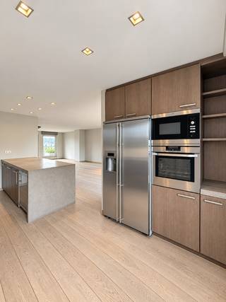 TE KOOP – GENT. Op een bijzonder gegeerde locatie aan de Visserij geniet u van een unieke woonbeleving met een totale oppervlakte van maar liefst 230 m² en circa 100 m² aan royale terrassen. Het adembenemende 180°-uitzicht over het water en de groene omgeving vormt hier elke dag opnieuw het decor.<br />De verschillende terrassen nodigen uit om volop van het buitenleven te genieten: van een rustig ontbijt in de ochtendzon tot een aperitief of lange zomeravond met familie en vrienden.<br />Ook binnen voelt u zich meteen thuis. De massief houten parketvloer, natuurlijke materialen en kwalitatieve afwerking creëren een warme, stijlvolle sfeer. Grote raampartijen halen het landschap naar binnen en verbinden de leefruimtes naadloos met de terrassen.<br />De inkomhal met ingemaakte vestiairekast biedt toegang tot het gastentoilet, een eerste badkamer en een ruime slaapkamer, momenteel ingericht als bureau. Vervolgens ontvouwt zich de royale leefruimte met volledig uitgeruste open keuken, hoogwaardige toestellen, een centraal kookeiland en een geïntegreerde wijnkoeler: de ideale plek om samen te koken, te aperitieven en uitgebreid te tafelen.<br />Via de elegante houten draaitrap bereikt u de bovenverdieping en het ruime zonneterras, waar u in alle privacy van het panoramische uitzicht geniet. Hier bevinden zich twee volwaardige slaapkamers, een stijlvolle badkamer, een aparte dressing en een praktische wasruimte met wasmachine en droogkast.<br />Talrijke ingemaakte kasten, doordachte opbergoplossingen en meerdere buitenbergingen bieden uitzonderlijk veel comfort zonder afbreuk te doen aan het ruimtelijke gevoel.<br />Een zeldzaam penthouse waar royale volumes, hoogwaardige afwerking en uitzonderlijk buitenleven samenkomen op een unieke ligging aan de Visserij.<br />Mogelijkheid tot aankoop autostaanplaats in het gebouw.