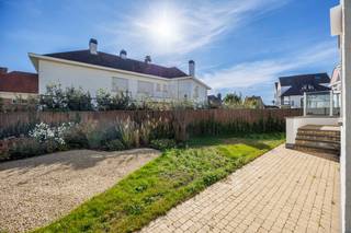Deze prachtige alleenstaande villa is gelegen op een bijzonder gegeerde locatie, op slechts enkele passen van de Zeedijk. De eigendom onderscheidt zich door haar royale volumes, stijlvolle afwerking en doordachte indeling, met maar liefst vijf slaapkamers, meerdere badkamers, uitnodigende zonneterrassen en een aangename tuin.<br /><br />Indeling:<br />Gelijkvloers: ruime en verzorgde inkomhal met vestiaire en afzonderlijk gastentoilet. De sfeervolle leefruimte geniet van een overvloed aan natuurlijk licht en biedt rechtstreeks toegang tot het zonnige terras en de tuin. De aansluitende eetruimte en volledig uitgeruste open keuken vormen samen een harmonieus geheel, waar gezelligheid en functionaliteit centraal staan.<br /><br />Eerste verdieping: op deze verdieping bevindt zich de royale hoofdslaapkamer, voorzien van ingemaakte kasten en een luxueuze privébadkamer met douche, dubbele wastafel, toilet en sauna. Vanuit de slaapkamer is er directe toegang tot een heerlijk zonneterras. Daarnaast beschikt deze verdieping over een tweede ruime slaapkamer met maatkasten en een eigen badkamer, uitgerust met een inloopdouche en dubbele wastafel.<br /><br />Tweede verdieping: hier bevinden zich twee bijkomende volwaardige slaapkamers, waarvan één bijzonder ruim en voorzien van ingemaakte kasten. De andere slaapkamer biedt voldoende plaats voor twee afzonderlijke bedden. Een aparte badkamer met ligbad, wastafel en toilet vervolledigt deze verdieping.<br /><br />Kelderverdieping: de villa is volledig onderkelderd en beschikt hier over een vijfde slaapkamer met eigen douchekamer. Daarnaast zijn er verschillende bijkomende ruimtes die zorgen voor extra bergruimte en praktische mogelijkheden.<br /><br />Parkeergelegenheid: een ruime garage en een private oprit met parkeermogelijkheid voor twee extra wagens bieden alle comfort voor bewoners en gasten.<br /><br />Contacteer ons voor bijkomende informatie of een vrijblijvend bezoek.