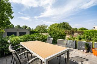 Dit ruim, instapklaar appartement is gelegen op een gegeerde en uiterst residentiële locatie in Wijnegem. U bevindt zich nabij openbaar vervoer, winkels, scholen en het centrum van Wijnegem. <br /><br />We betreden het appartement via privatieve inkom. Deze brengt ons naar de ruime leefruimte waar de grote raampartijen en het halfopen karakter van de woonst, zorgen voor een aangename lichtinval. De open, volledig geïnstalleerde keuken sluit hier naadloos op aan en is uitgerust met een 5 pits gasvuur, oven, microgolfoven, combi-oven, dampkap, spoelbak met verlek, vaatwasser en een koelkast. Vanuit de leefruimte hebben we rechtstreeks toegang tot het gezellige en zonnige zuid-terras met tuin, de ideale plek om te genieten van een BBQ met vrienden of familie.<br /><br />Op het gelijkvloers bevinden zich verder een apart toilet, een bureauruimte alsook een praktische berging. <br />Achteraan deze woonst vinden wij nog een extra dubbele berging of garage van 40 m² terug. <br /><br />De souterrain omvat maar liefst vier slaapkamers (14,5m² / 9m² / 8,5m² / 8m²) alsook de badkamer met inloopdouche, hangtoilet en dubbele lavabo.<br />Daarbovenop is er een extra berging en een technische ruimte met aansluiting voor wasmachine aanwezig.  <br /><br />Ook op vlak van energiezuinigheid scoort deze woonst uitstekend. Het beschikt over vloerverwarming, 12 zonnepanelen, ventilatiesysteem type D en een regenwaterput van 10.000 liter die is aangesloten op de toiletten. <br /><br />Als extra troef is er een achtergelegen grond (4.000 m²) dewelke mee aangekocht dient te worden aan € 45.000, wat heel wat mogelijkheden biedt. Momenteel is deze voorzien van volwassen wijnranken en een uitgebreide moestuin.  <br /><br />Pluspunten:<br />- 4 slaapkamers<br />- ruim appartement<br />- zonnig terras en tuin<br />- uitstekende staat en instapklaar<br />- garage/berging (42,5m²)<br />- regenwaterput (10.000 liter)<br />- videofoon<br />- 12 zonnepanelen<br />- EPC A<br />- aanhorende grond bij aan te kopen (€ 45.000) <br />- centrale locatie in Wijnegem<br /><br />Interesse in deze instapklare woning? Contacteer ons via 03 337 50 70 of info@vbvastgoed.be voor meer info of een afspraak. 