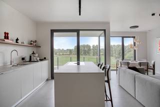 Dit stijlvolle appartement van 104 m² (BVO) bevindt zich op de eerste verdieping van de gerenommeerde Residentie The Vineyard. Het omvat een ruime en lichtrijke leefruimte met volledig uitgeruste keuken en keukeneiland, een aansluitende berging, ruime master bedroom en een 2e slaapkamers, een badkamer en apart toilet. Daarnaast beschikt het over twee terrassen (in totaal 10m²), waarvan één uitkijkt over de toekomstige wijngaard en het glooiende landschap van de Vlaamse Ardennen. Dankzij de grote raampartijen geniet u vanuit de leefruimte en een van de terrassen optimaal van het groen en de rust. De hoogwaardige afwerking, hedendaagse architectuur en doordachte indeling zorgen voor een comfortabel en tijdloos woonconcept. Het appartement is reeds voorzien van vliesbehang en schilderwerken. Op energetisch vlak beschikt het over een warmtepomp, vloerverwarming en hoogrendementsglas. Tevens bestaat de mogelijkheid om zonnepanelen te voorzien. De verkoopprijs van de inpandige parkeerplaats en een extra berging bedraagt € 20.000 excl. btw. Indien gewenst kunnen ook twee parkeerplaatsen aangekocht worden. Residentie The Vineyard geniet een uitstekende ligging nabij Oudenaarde, Zottegem, Ronse en Geraardsbergen. U woont er midden in het groen, met een weids uitzicht over het agrarische landschap, terwijl winkels, horeca, scholen en andere voorzieningen vlot bereikbaar zijn. Een unieke combinatie van stijlvol wonen, rust, ruimte en natuur in het hart van de Vlaamse Ardennen. Er is tevens een mogelijkheid om 2 parkeerplaatsen aan  Prijzen excl. BTW. Enkel een schriftelijk bod dat door de verkopers wordt aanvaard, leidt tot een verbintenis of verkoop. <br /> 