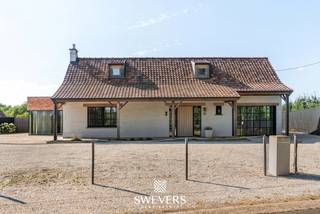 Voor meer info en foto’s, surf naar www.swevers.be – Welkom in de Keelstraat 94 in Sint-Truiden. Deze volledig gerenoveerde open bebouwing (2019) combineert het karakter van de oorspronkelijke woning uit 1976 met hedendaags comfort, hoogwaardige materialen en een luxueuze afwerking. Met een bewoonbare oppervlakte van 276 m² op een perceel van 28 are 50 centiare geniet u van ruimte, rust en een prachtig vrij uitzicht over het achterliggende agrarische gebied. De lichtrijke leefruimte sluit naadloos aan op de royale leefkeuken met kookeiland. Verder beschikt de woning over vier volwaardige slaapkamers, een stijlvolle badkamer, een dressing, een praktische wasberging en technische ruimte. Een aparte polyvalente ruimte met eigen inkom, toilet en keukentje biedt tal van mogelijkheden als praktijk, kantoor, studio of hobbyruimte. Dankzij de slaapkamer en badkamer op het gelijkvloers is ook gelijkvloers wonen perfect mogelijk. Buiten geniet u van een zuidgerichte tuin en ruim terras waar privacy en zon centraal staan. Domotica, airconditioning, alarmsysteem, videofoon, jacuzzi, zonnepanelen (ca. 4.000 kWh/jaar), maatwerk en een mindervalidentoegankelijke inrichting zorgen voor een uitzonderlijk wooncomfort. Bovendien zijn er ruime parkeermogelijkheden op eigen terrein. De rustige ligging wordt perfect aangevuld met een vlotte bereikbaarheid van scholen, winkels, horeca en ontspanning. Een ideale woning voor gezinnen of wie wonen en werken wil combineren. Voor meer informatie, bel 011 255 155. Bron bewoonbare oppervlakte: EPC – verslag.