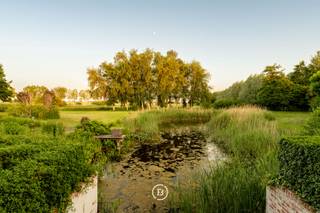 Deze karaktervolle hoeve bevindt zich in een discrete, landelijke omgeving en wordt aangeboden op een uitzonderlijk ruim perceel van in totaal 21.760 m². De combinatie van ruimte, groen en prachtige vergezichten over de omliggende weilanden zorgt voor een bijzonder aangename en rustige woonomgeving.<br /><br />De zuidgerichte tuin sluit mooi aan op de woning en beschikt over een terras en vijver. Daarnaast is er een ruime garage met plaats voor meerdere wagens, een werkruimte en voldoende opslagmogelijkheden voor tuinmateriaal.<br /><br />Binnenin is de woning praktisch en ruim opgevat. De lichtrijke woonkamer met hoog plafond vormt het hart van de woning en geniet, net als verschillende andere ruimtes, van een mooi contact met de groene omgeving. Verder beschikt de eigendom over een volledig uitgeruste keuken, zes slaapkamers en drie badkamers.<br /><br />Met een totale grondoppervlakte van 21.760 m² is dit een interessante eigendom voor wie op zoek is naar een karaktervolle hoeve met veel ruimte, privacy en een uitgesproken landelijk karakter.