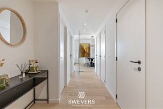 Voor meer info en foto’s, surf naar www.swevers.be – Ontdek dit instapklare luxe dakappartement op de 3de verdieping, gebouwd in 2022, pal in het centrum van Beringen. Met een bewoonbare oppervlakte van 105 m², drie slaapkamers, twee badkamers en een uitzonderlijk terras van 60 m² geniet u hier van comfortabel wonen met alle voorzieningen op wandelafstand. Winkels, horeca en ontspanning bevinden zich op amper 10 meter, openbaar vervoer op 170 meter, scholen op 230 meter en de autosnelweg bereikt u na ongeveer 3,6 km. De inkomhal geeft toegang tot alle ruimtes. De lichtrijke leefruimte van 37 m² vormt samen met de open keuken van 11,86 m² een aangename woonzone met voldoende plaats voor een gezellige zithoek en eethoek. Aansluitend bevindt zich een praktische berging. Het appartement beschikt over drie slaapkamers, waarvan de grootste 12,98 m² meet. De twee overige kamers zijn ideaal als kinderkamer, bureau of hobbyruimte. Dankzij de twee badkamers en het apart toilet geniet u bovendien van extra comfort in het dagelijkse leven. De absolute blikvanger is het ruime terras van 60 m² dat aansluit op zowel de leefruimte als de slaapkamers. Hier creëert u moeiteloos verschillende zithoeken of een gezellige buitenruimte om volop van het mooie weer te genieten. Bent u op zoek naar een recent, ruim en instapklaar appartement op een toplocatie in Beringen? Dan is dit luxe appartement zeker een bezoek waard. Voor meer informatie, bel 011 255 155. Bron bewoonbare oppervlakte: EPC – verslag.