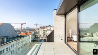 <p>Dit hoogwaardige nieuwbouwpenthouse bevindt zich op een uitzonderlijke locatie, op slechts enkele meters van de Zeedijk en het Rubensplein. De combinatie van verfijnde architectuur en ruime terrassen creëert een naadloze overgang tussen binnen- en buitenleven, wat resulteert in een exclusieve woonervaring.</p>
<p><strong>Indeling</strong><br />De inkomhal beschikt over een vestiaire en gastentoilet. De lichtrijke leefruimte opent naar een ruim, zuidgericht terras, ideaal voor ontspanning of ontvangst van gasten. De open keuken, uitgerust met premium apparatuur, grenst aan de eetruimte en biedt toegang tot een tweede terras, perfect voor sfeervolle diners.</p>
<p>Voor extra comfort is er een aparte berging met aansluiting voor wasmachine en droogkast. Op de bovenverdieping bevindt zich de master bedroom met ingemaakte kasten en een luxueuze badkamer. Daarnaast zijn er twee volwaardige slaapkamers, eveneens voorzien van maatwerk kasten, die een moderne douchekamer delen. Alle slaapkamers zijn uitgerust met airconditioning. Het penthouse beschikt over vloerverwarming en een privatieve kelder.</p>
<p>Dit eigendom wordt verkocht onder het btw-stelsel en biedt een unieke kans om zorgeloos te wonen op een van de meest gegeerde locaties in Knokke.</p>